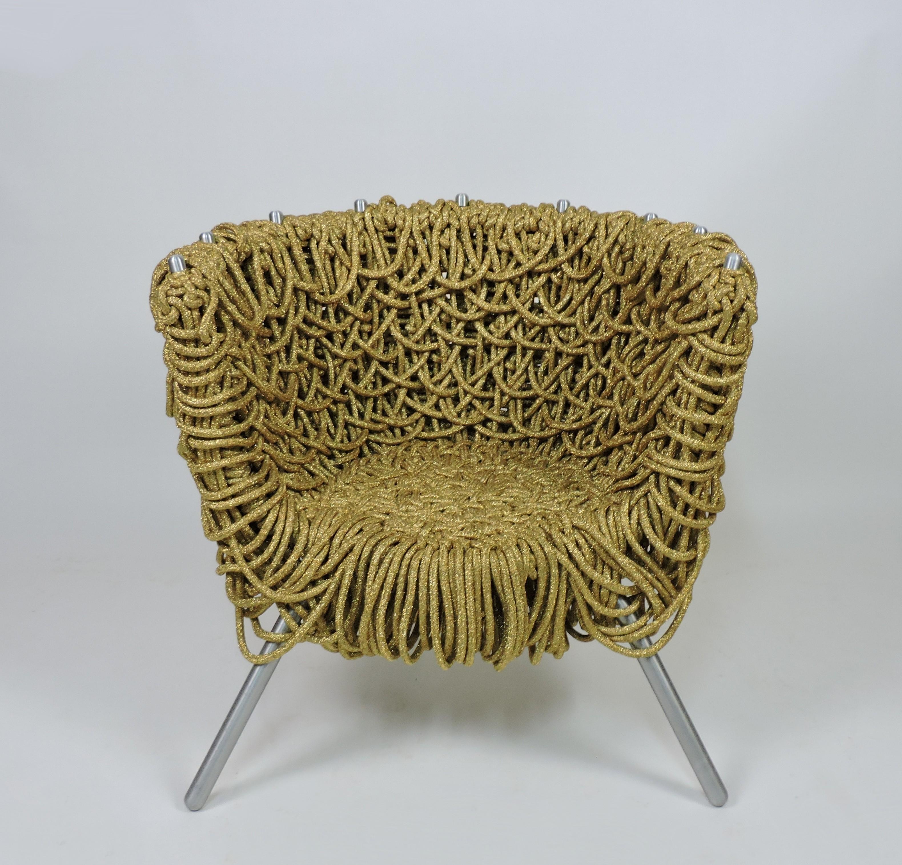 Fauteuil unique et emblématique conçu par les célèbres designers brésiliens Fernando et Humberto Campana,                et fabriqué en Italie par Edra. Cette chaise est faite de corde métallique dorée, de fer et d'aluminium. La chaise longue