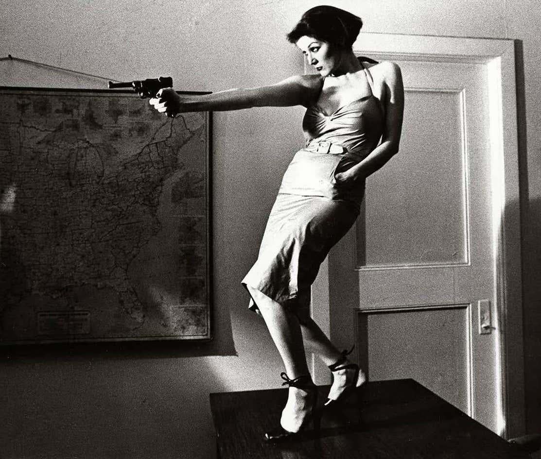 Girl With A Gun, Patti Astor East Village photo 1977 (The Foreigner)  - Photograph by Fernando Natalici