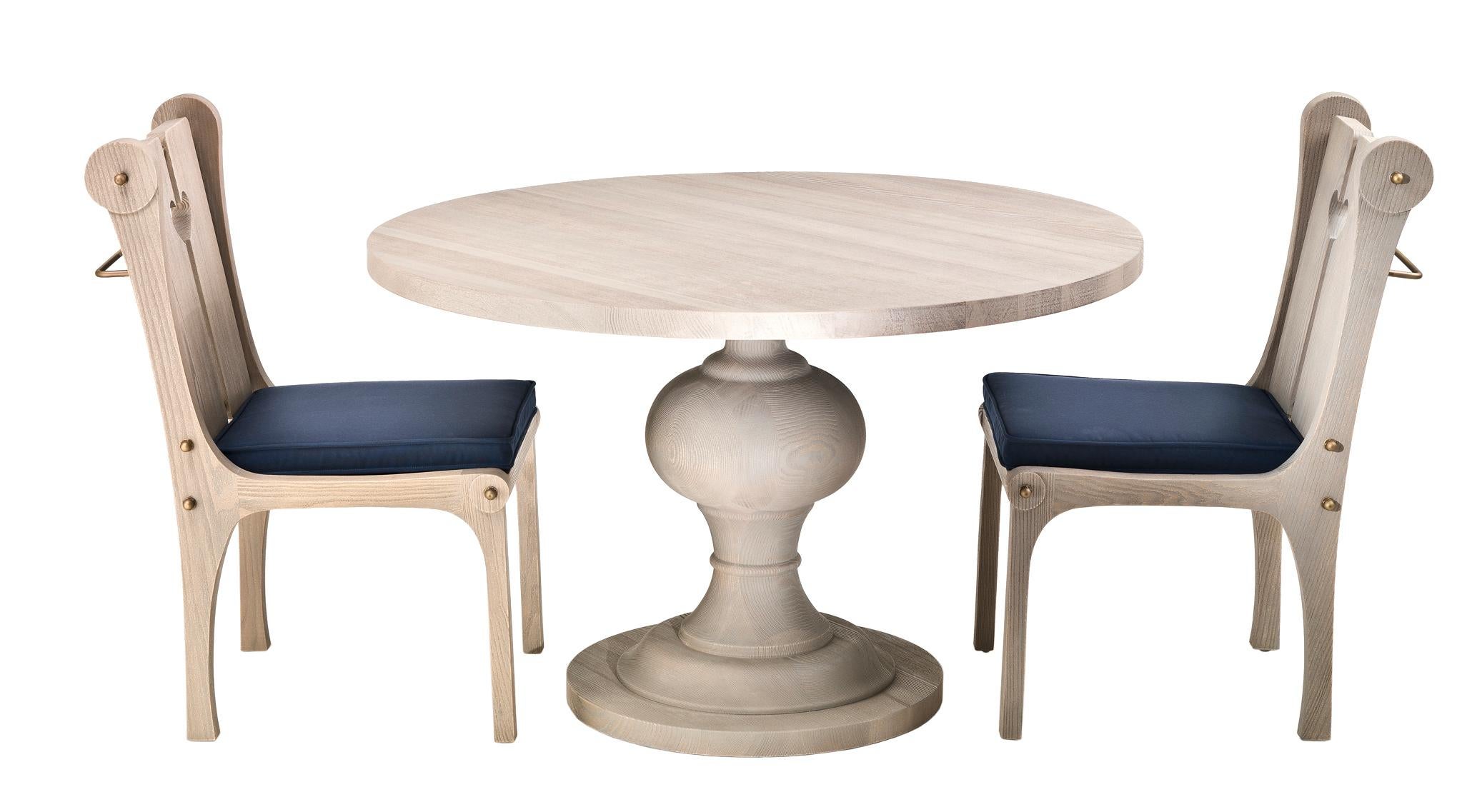 Cette table de salle à manger d'extérieur est fabriquée en bois de sassafras américain, avec un plateau en bois de cèdre. La base est élégamment tournée et solidement fixée au plateau par une plaque de métal, ce qui assure la stabilité de