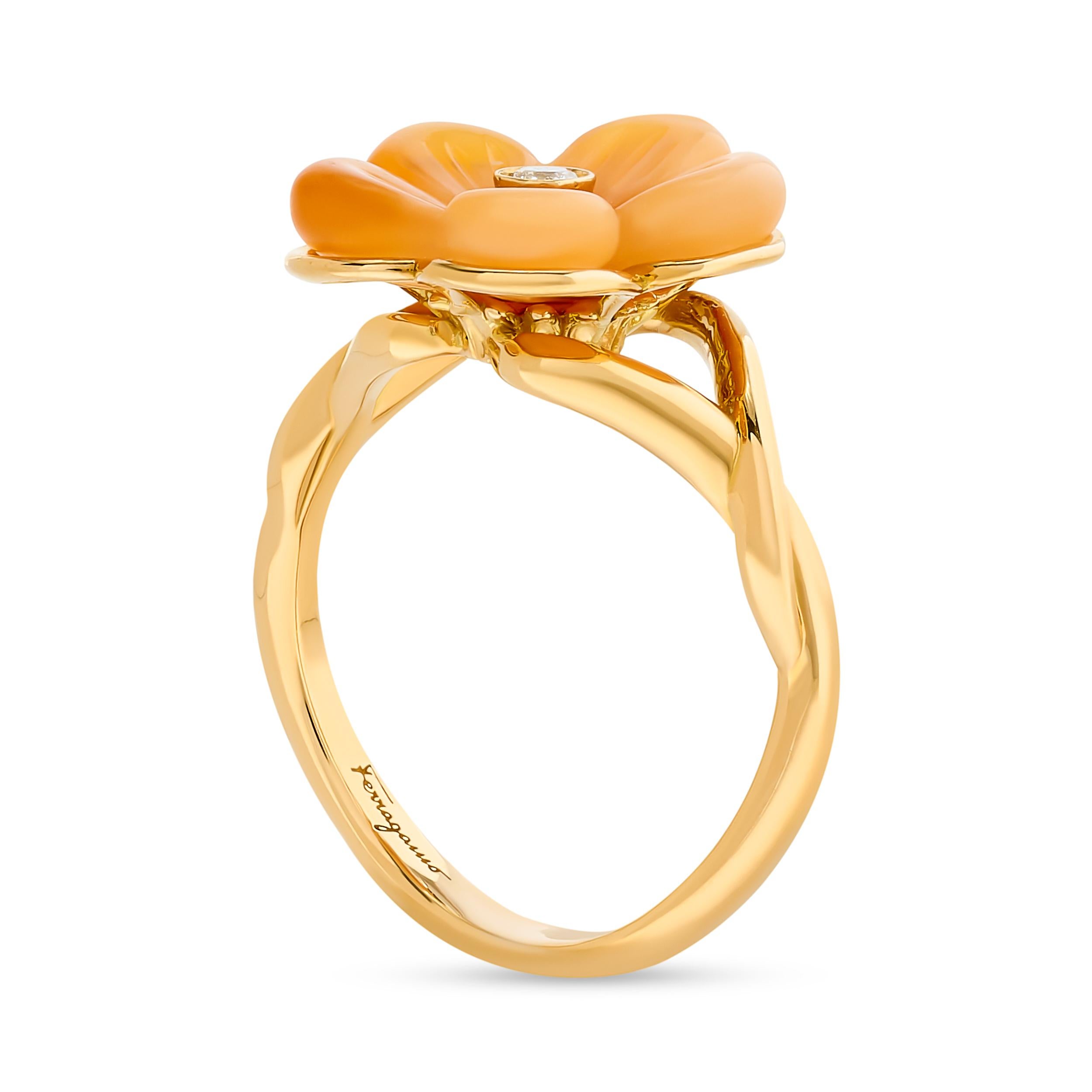 This exquisite 18 karat Ferragamo ring features a captivating floral design with carved, delicate fire opal petals that gently curve around a diamond center. *Please note, due to the nature of the opal, most of the flower is a solid, milky color