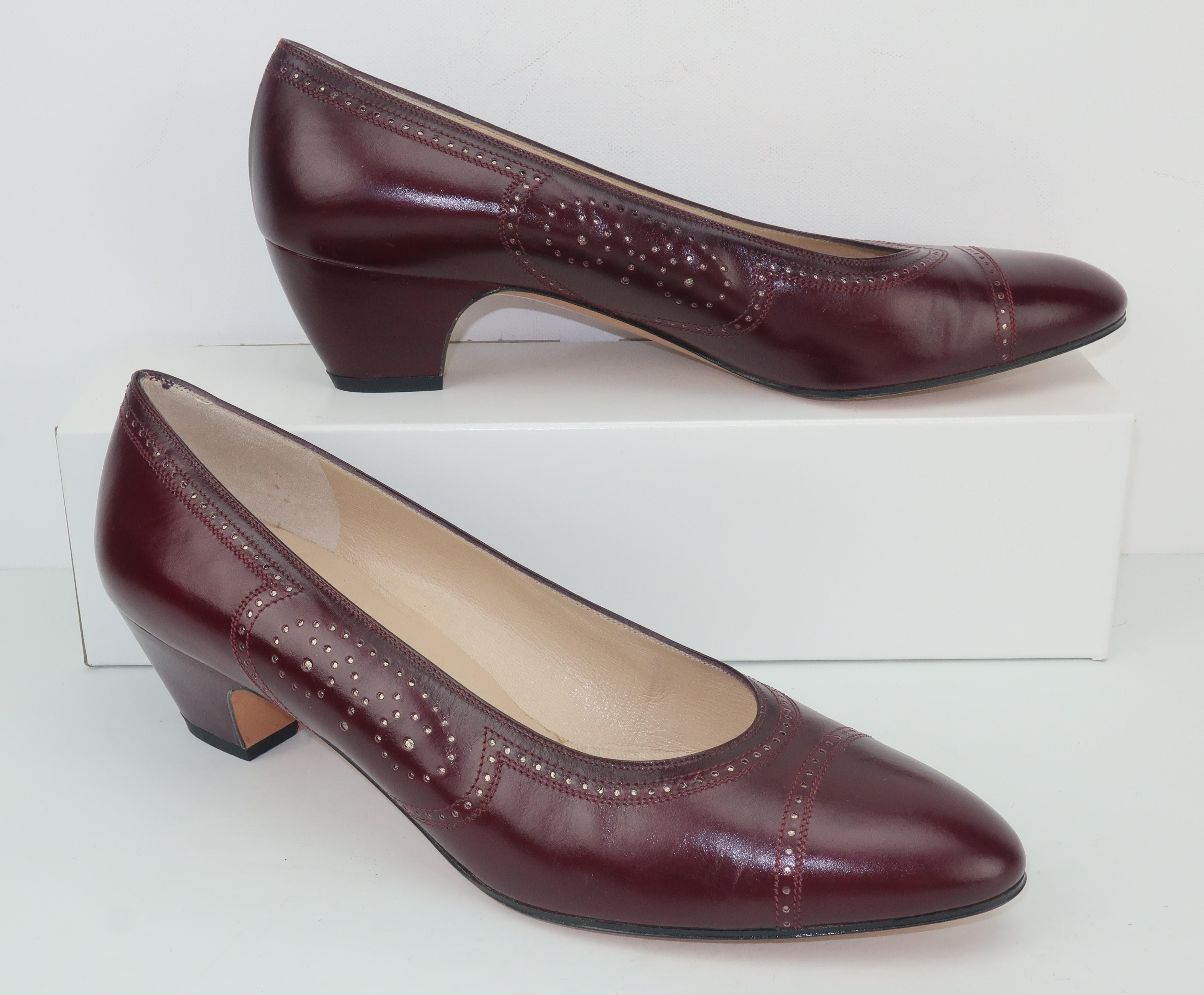 Classic Ferragamo sensibility with stylish details makes these burgundy leather shoes a functional option for casual wear or more professional attire.  The spectator style decoration adds a unique perforated design accented with a subtle gold