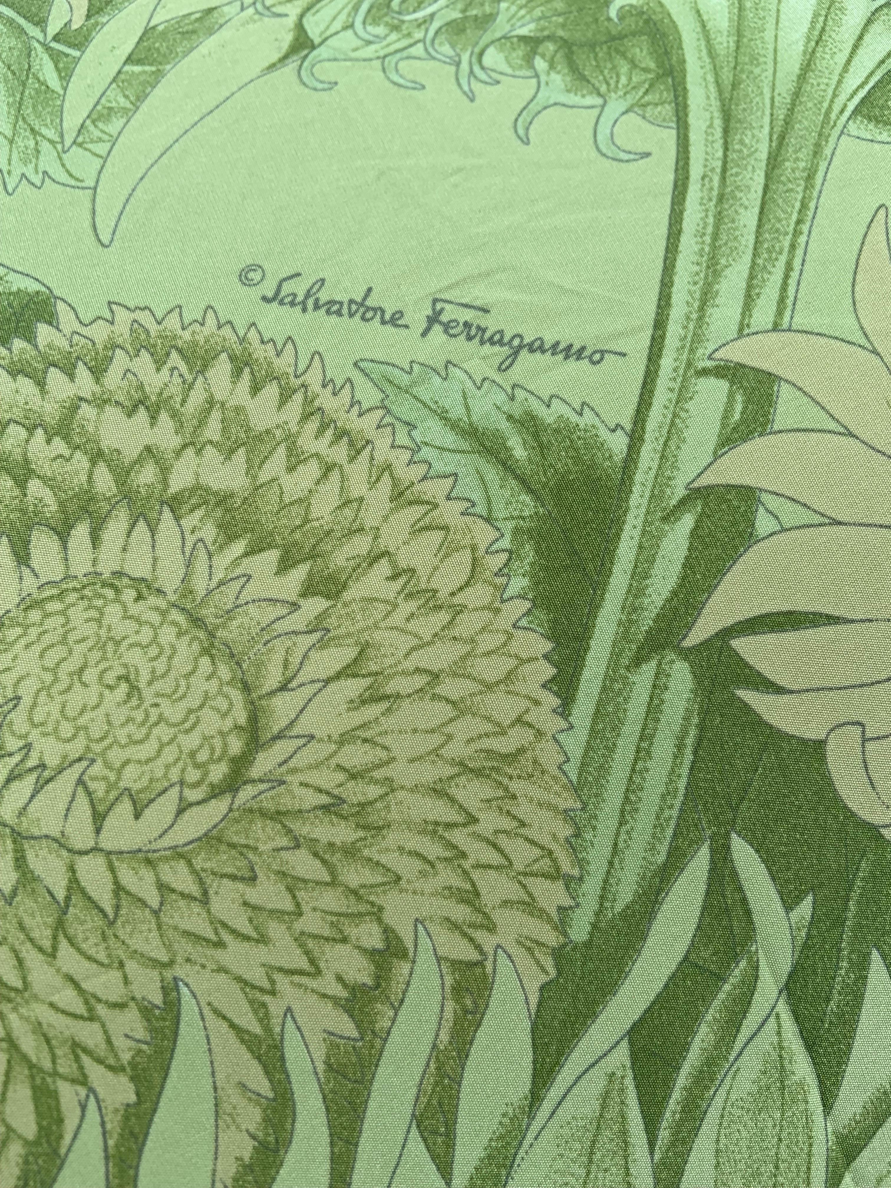 Ces magnifiques tournesols égayeront tous les jours de pluie !  Le parapluie pliable a une poignée en bois  avec un bracelet en cuir et une plaque en laiton avec le logo Ferragamo.  L'étui, ou la couverture, est imprimé dans le même tissu que le