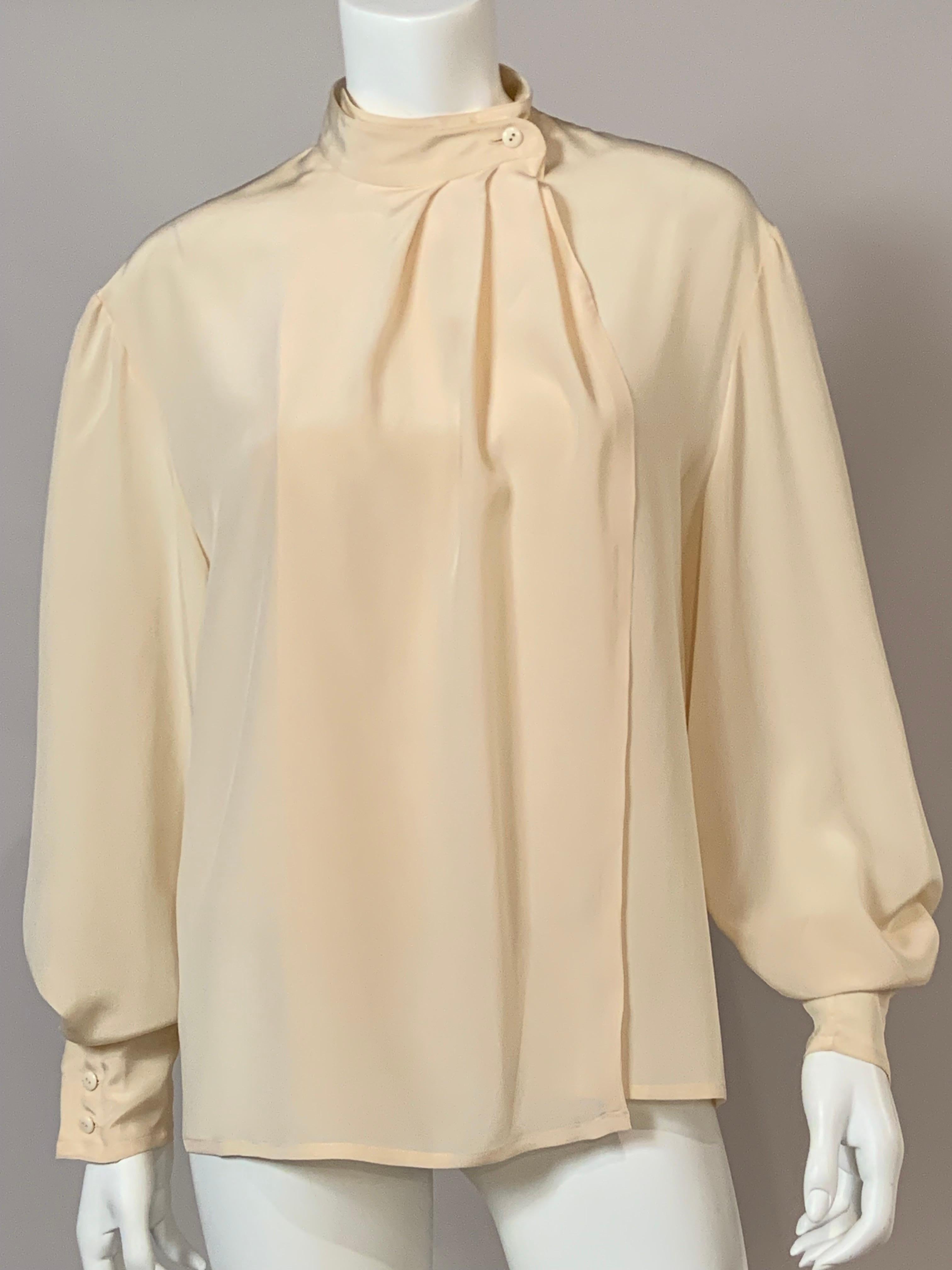 This ivory silk blouse from Ferragamo has a single button closure on the left side of the collar.  I am assuming that it is meant to be belted or tucked in.  The long sleeves have three buttons at the wrist.  It is in excellent condition, appears