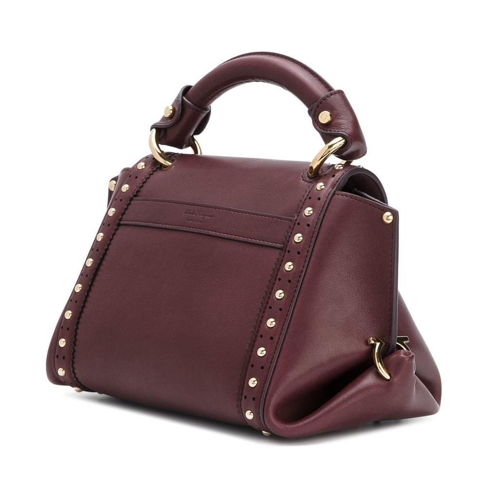 The Sofia satchel features a studded leather body, rolled top handle, flat strap, top flap with flip lock closure, exterior slip pocket, and interior zip pockets. It carries as AB condition rating.

Inclusions: 
This item does not come with