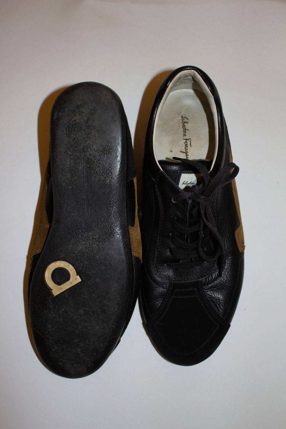 Une superbe paire de baskets Ferragamo.  Comme on peut s'y attendre, ils sont magnifiquement réalisés en daim et en cuir dans une combinaison de noir et de marron.
Numéro de série VG 2706 , taille 9 , fabriquées en Italie, elles ont une semelle