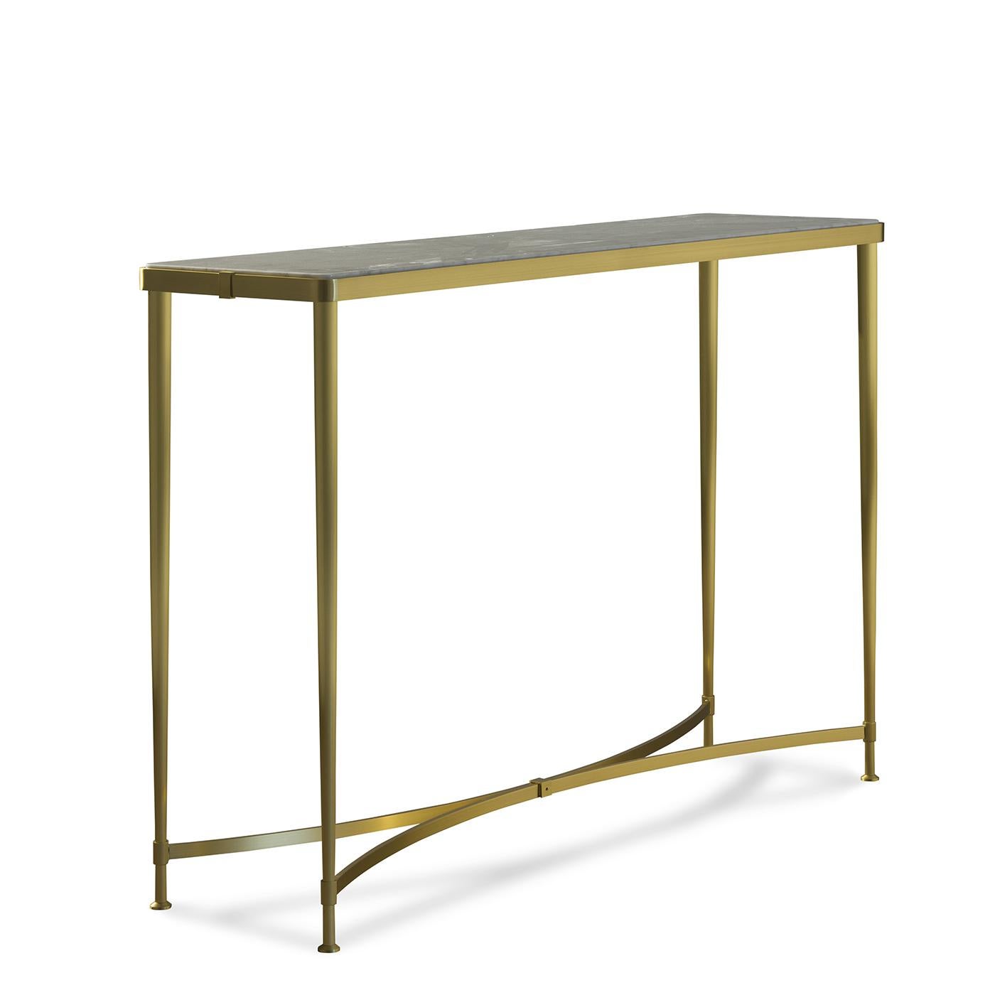 The linear Silhouette of this stunning console will be an exquisite addition to an entryway, setting the tone for an elegant home. Its structure in brass with a satin finish comprises a sinuous base that supports a set of four slim legs raising to