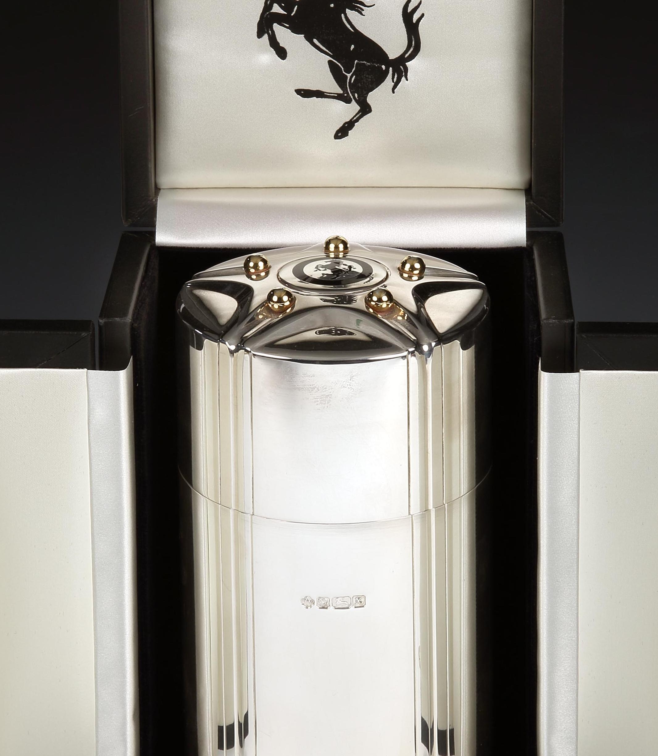 Asprey & Co. for Ferrari

An extremely unusual sterling silver cigar canister, the straight-sided 'drum' body with lift-off lid has the distinctive five-pointed wheel spoke design to the top with a central black enamel Cavallino Rampante, similar to