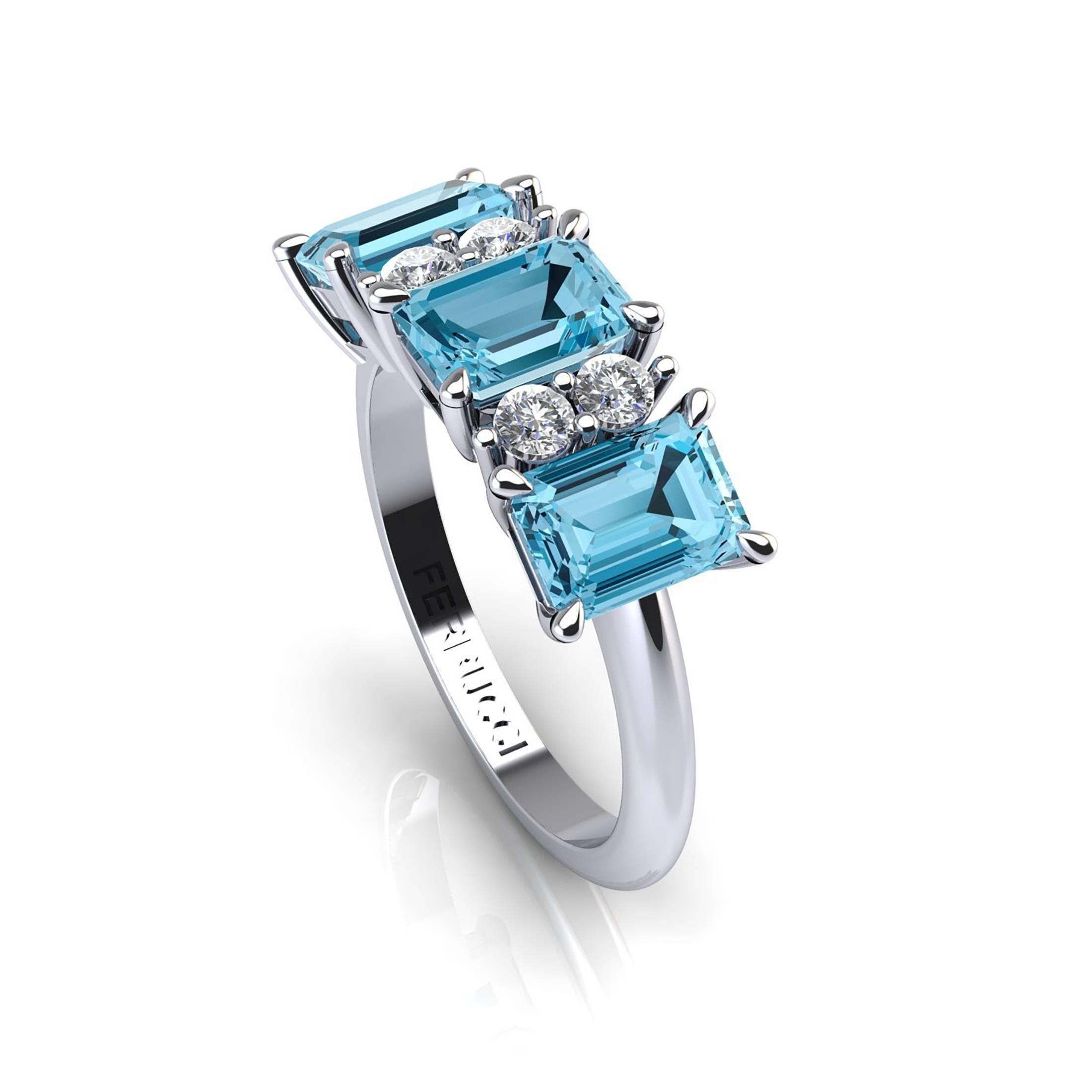 Stunning three gemstone ring and diamonds, showcasing natural Blue Topazes emerald cut gem, and white diamonds G color for an approximate total carat weight of 0.18ct.
This ring is entirely hand made in 18k white gold in New York city, the finger