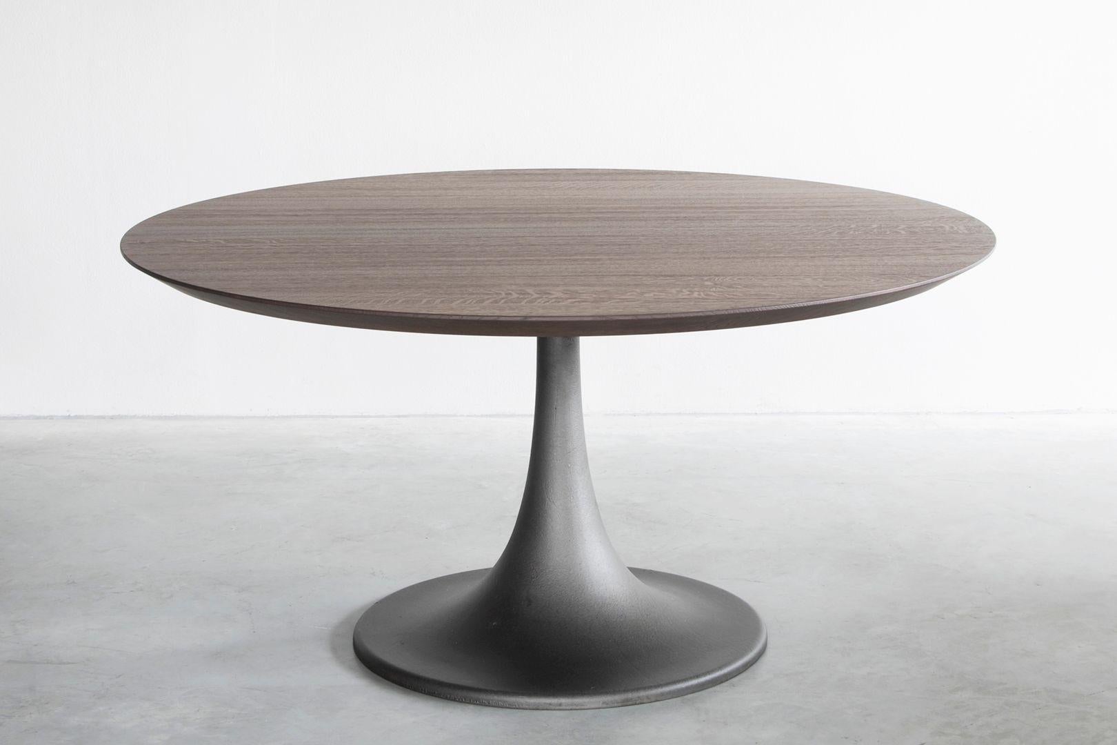 Ferrum dining table by Van Rossum
Dimensions: D170 x W170 x H74 cm
Materials: Oak, Iron.

The wood is available in all standard Van Rossum colors, or in a matching finish to customer’s own sample. The base of Ferrum is hand-moulded, and