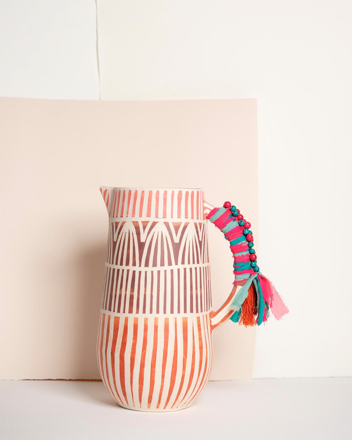 A handmade jug for your next soiree
The Fest Handmade Ceramic Jug is a whimsical party must-have. Crafted from white ceramic with red glaze and delicate handmade details like beads and cotton thread, this jug also features a striped texture. Great