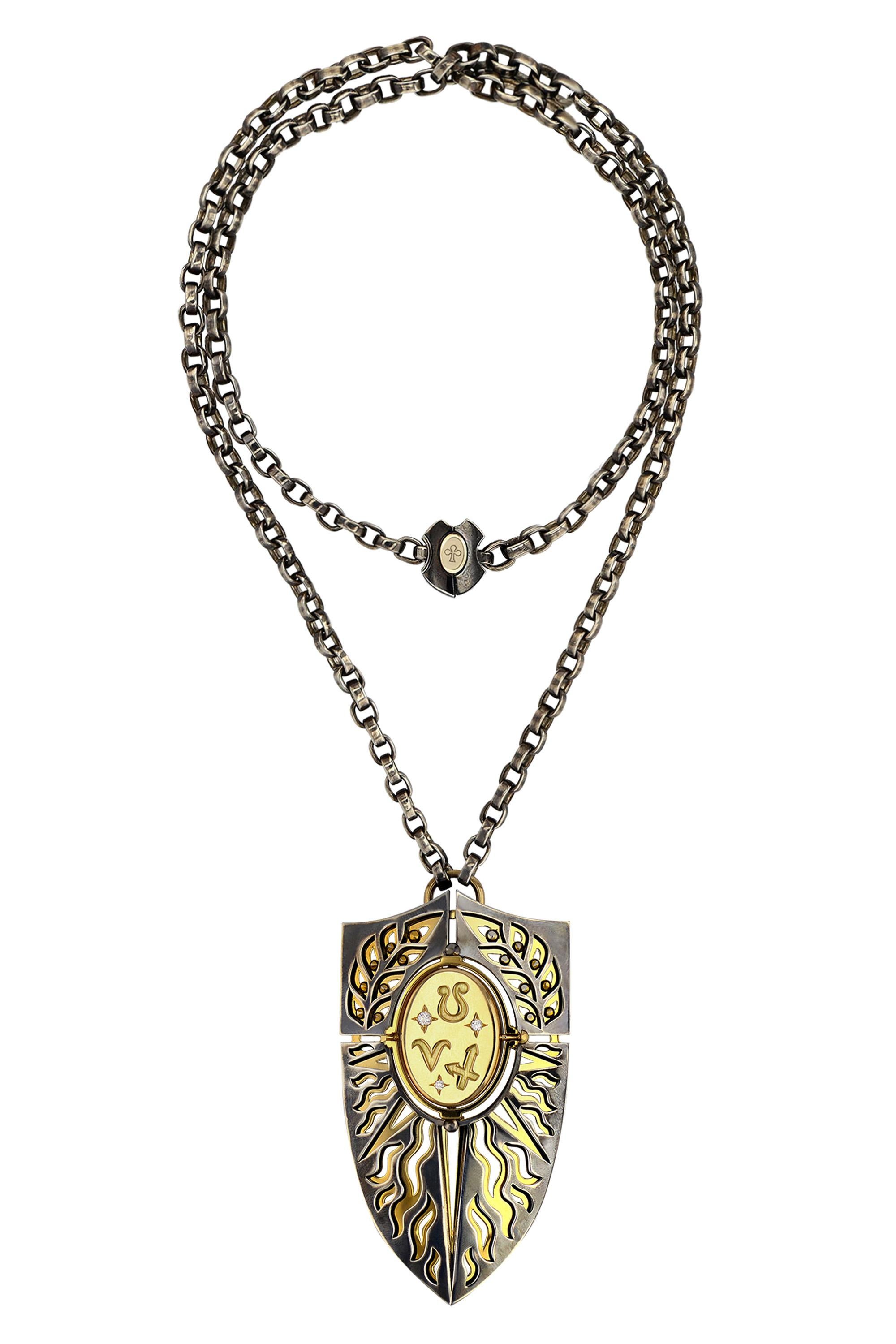 Yellow gold and distressed silver pendant. Rotating medallion: the signs of Fire (Aries, Leo, Sagittarius) engraved on the gold and on the carnelian, a salamander.

Distressed silver chain. 

Details:
Carnelian
3 Diamonds: 0.1 cts
18k Yellow Gold: