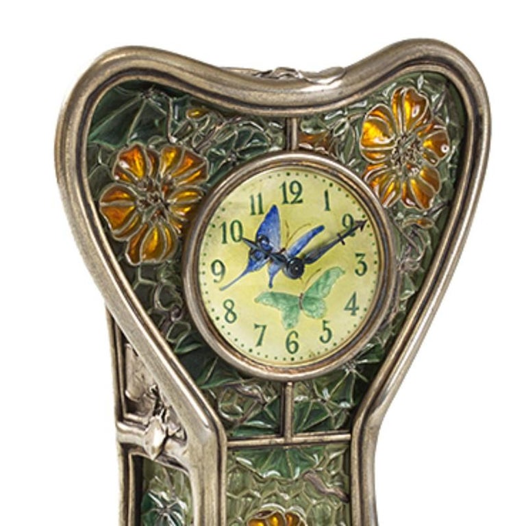This rare French Art Nouveau silver and plique-à-jour enamel clock depicts a dynamic display of butterflies and flowering 