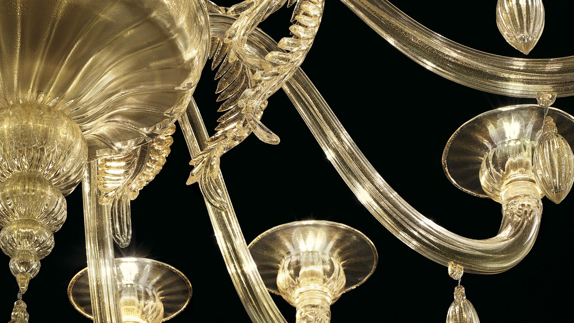 The Fez 5602 12 chandelier was originally designed in 2011, and is shown here in Gilded Gold blown glass, and a Galvanized Gold finish. Gilded leaves and olive pendants feature in this collection of chandeliers and wall sconce with limited heights,