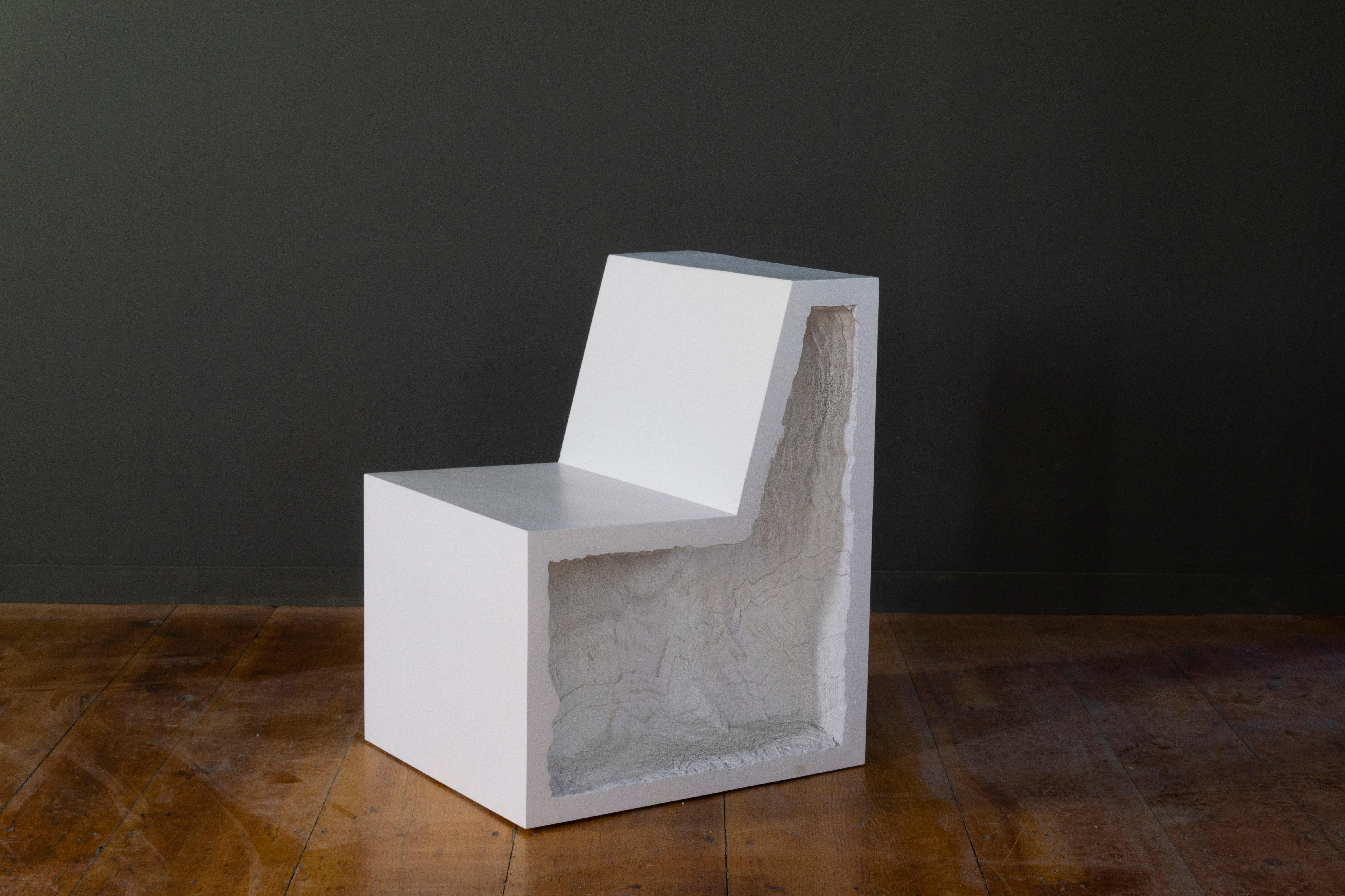 A heavy statement chair, with volumes reminiscent of brutalist architecture and deep textured voids. Depth of details are emphasized when the light reaches the voids, while the simple exterior planes become monochromatic geometric shapes.