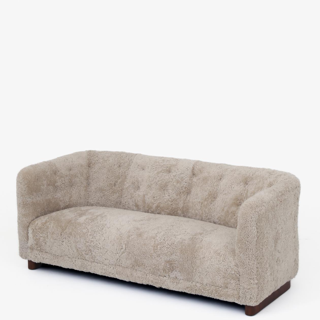 Model FH 1668 - Reupholstered sofa in new lambskin with natural leather buttons and stained beech legs. Ole Wanscher / Fritz Hansen.