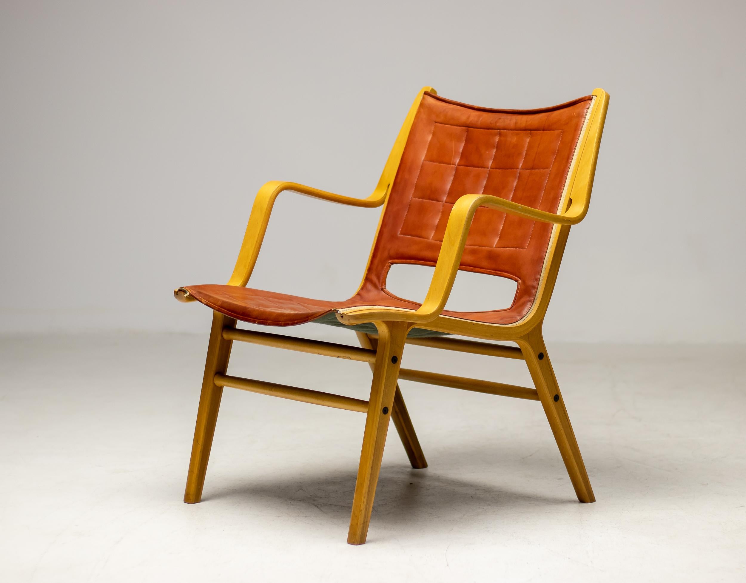Sessel, entworfen von Peter Hvidt und Orla Mølgaard-Nielsen, hergestellt 1963 von Fritz Hansen, Dänemark.  Der Stuhl ist aus laminiertem Buchenholz gepresst, die Sitzfläche ist mit dem originalen cognacfarbenen Leder gepolstert. Die Beine haben