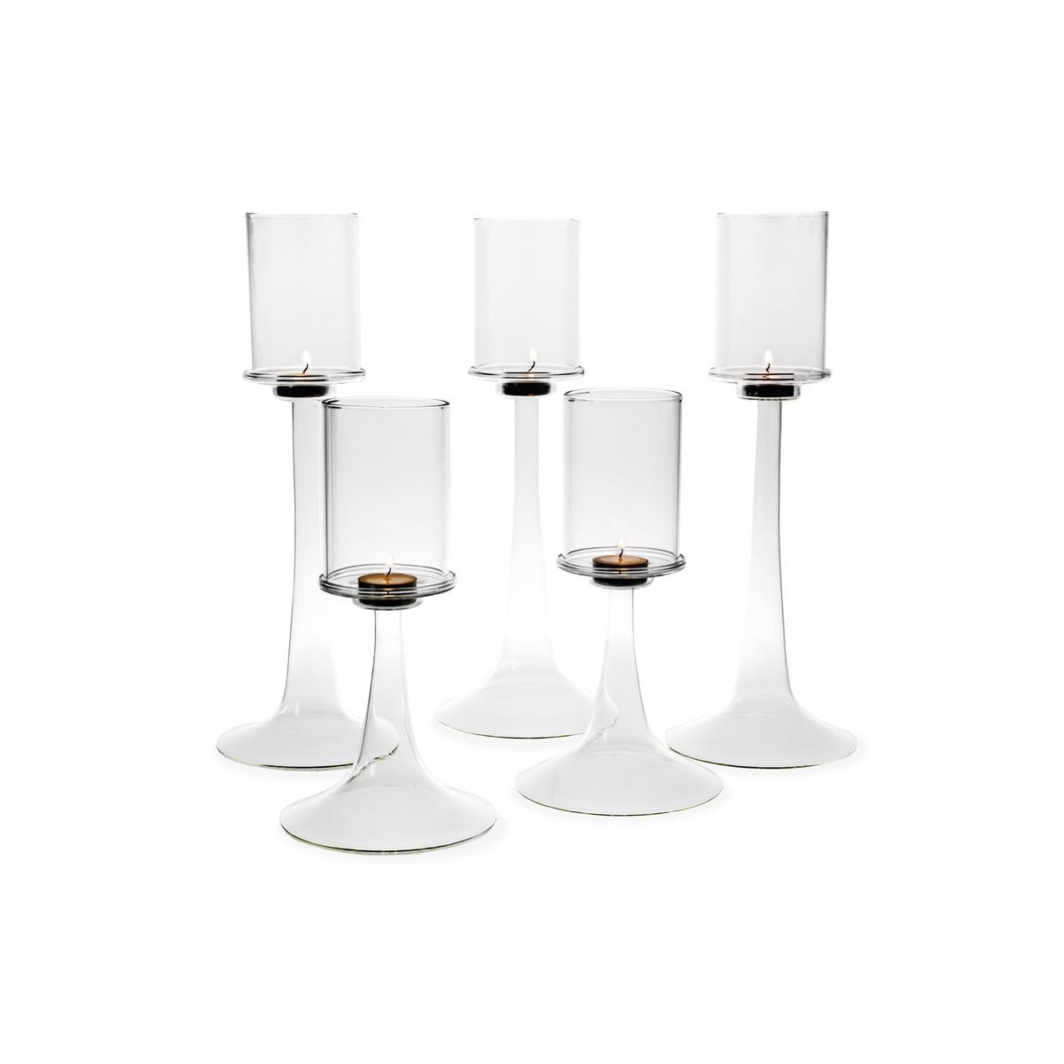Fiamma is an elegant candle holder in blown glass consisting of two elements: a tapered and slim base on which a cylindrical lampshade lays. Fiamma, designed by Aldo Cibic, is available also in a lower size.