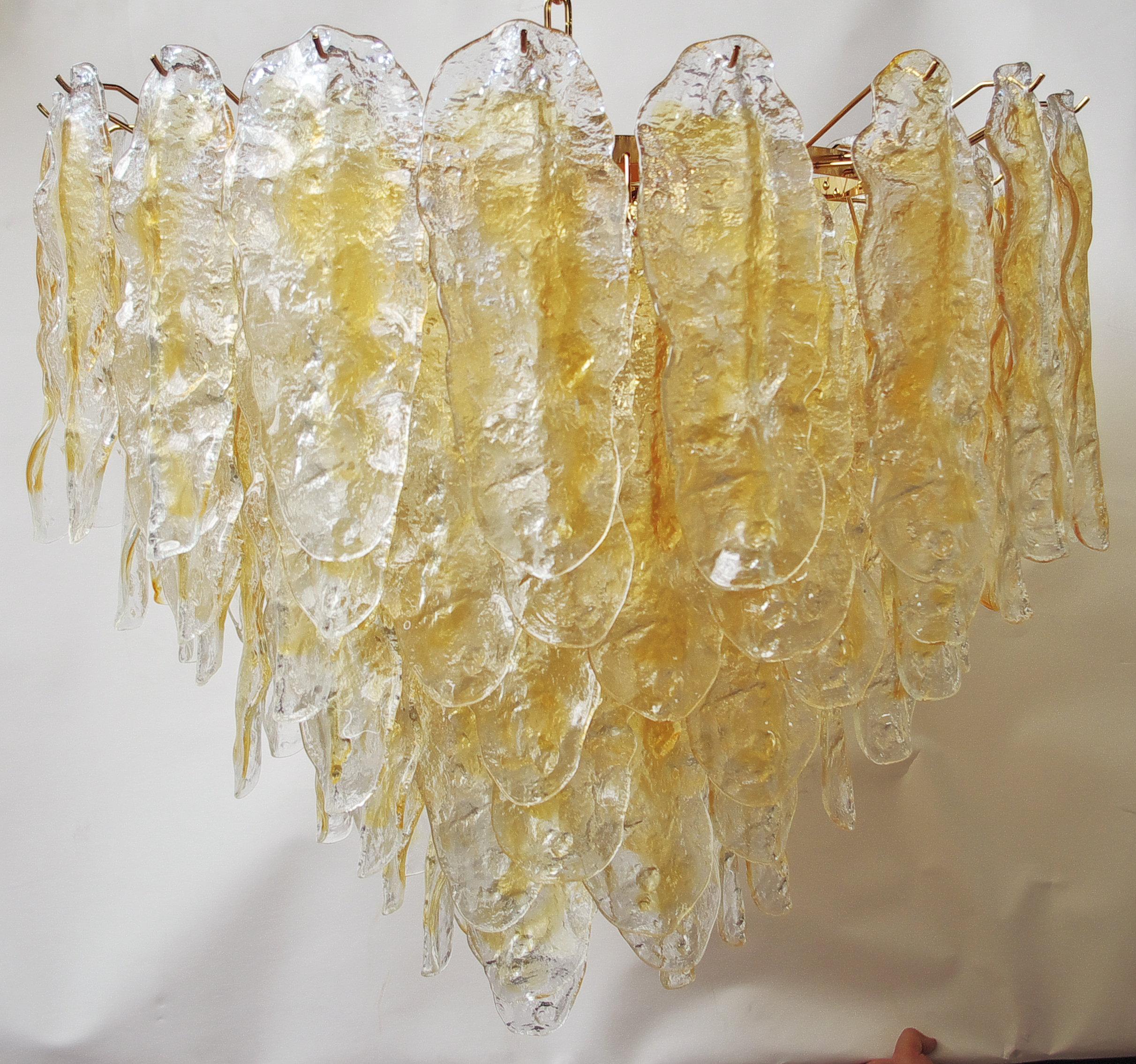Lampadario italiano con foglie in vetro di Murano trasparente e ambrato soffiato a mano, montato su una cornice placcata oro 24 carati di Fabio Ltd / Made in Italy
13 luci / E26 o E27 / max 60W ciascuna
Misure: Altezza: 27,5 pollici più catena e
