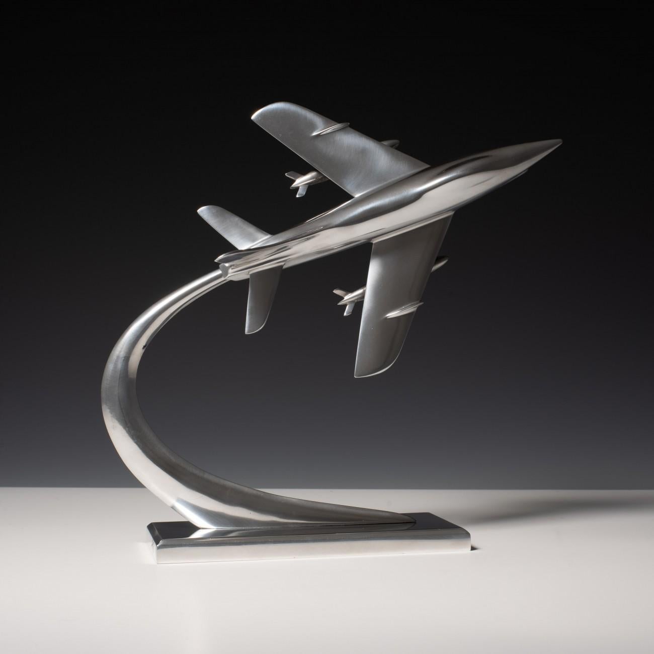 Stylish 1960s polished aluminium Fiat G.91 jet fighter model on original stand. The position of the aircraft on its stand can be adjusted by rotating the model along its horizontal axis.

Dimensions: 28 cm/11 inches (length) x 16.5 cm/6½ inches