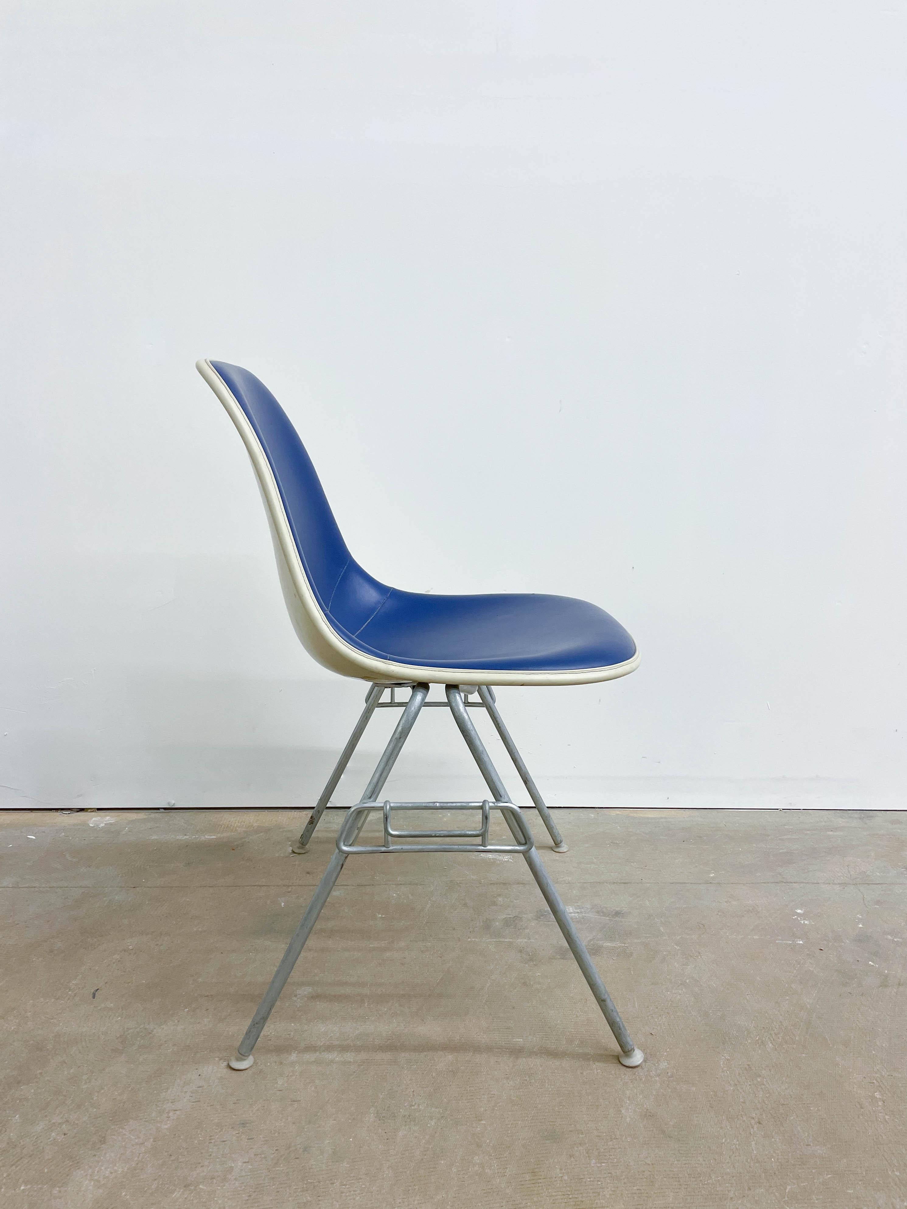 If you are searching for an iconic example of mid-century modern design, look no further! This fiberglass shell chair was designed by Charles and Ray Eames, the famous design duo. The fiberglass shell sits on a on stacking base. Made by Herman