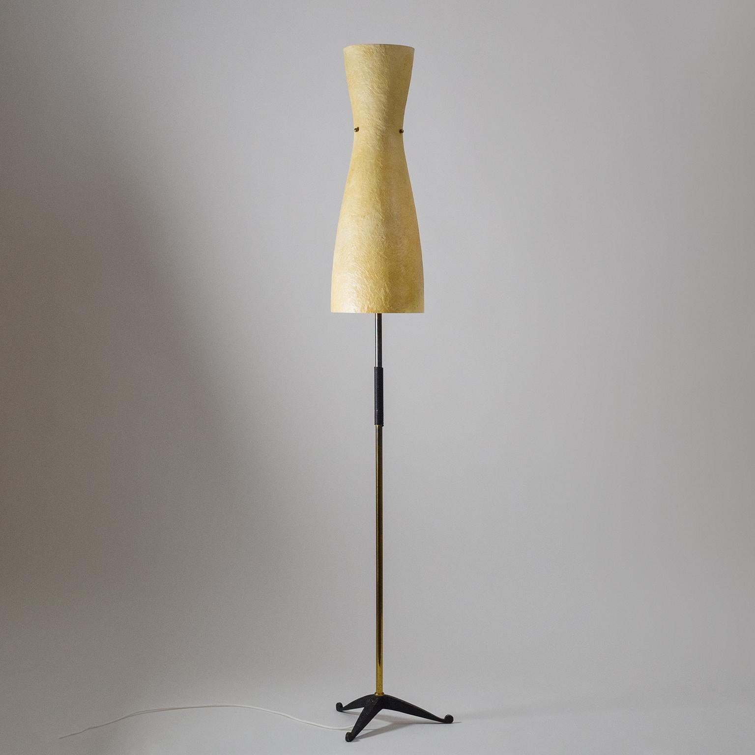 Wonderful 1950s standard lamp with a large fiberglass shade, brass stem with black nylon cord grip and cast iron tripod base. Very Fine midcentury design combining Stark modernist elements with organic shapes and surfaces. Three original brass E27