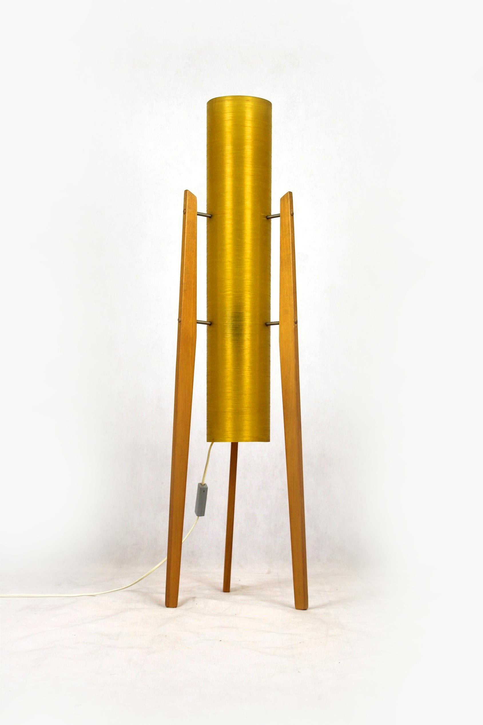 This floor rocket lamp was produced in the 1960s in Czechoslovakia.
It features yellow fiberglass shade on three wooden legs.
The lamp is fully functional, requires one bulb.