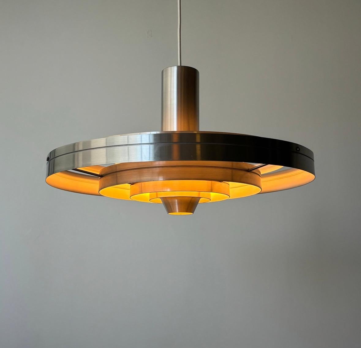 The vintage 'Fibonacci' pendant lamp, designed by Sophus Frandsen for Fog & Mørup in 1963, is a masterpiece of midcentury modern design. Crafted from aluminum, this pendant lamp draws inspiration from the Fibonacci sequence, with its elegantly