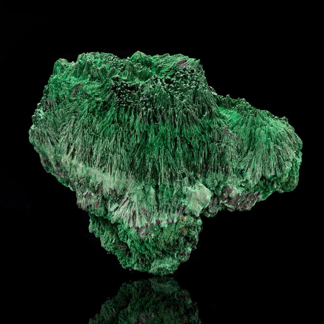 This large, verdant raw fibrous malachite specimen from the DRC features a dazzlingly sparkling, almost velvety luster. Named for the banded or fibrous way within which this species of the copper carbonate mineral forms, fibrous malachite often