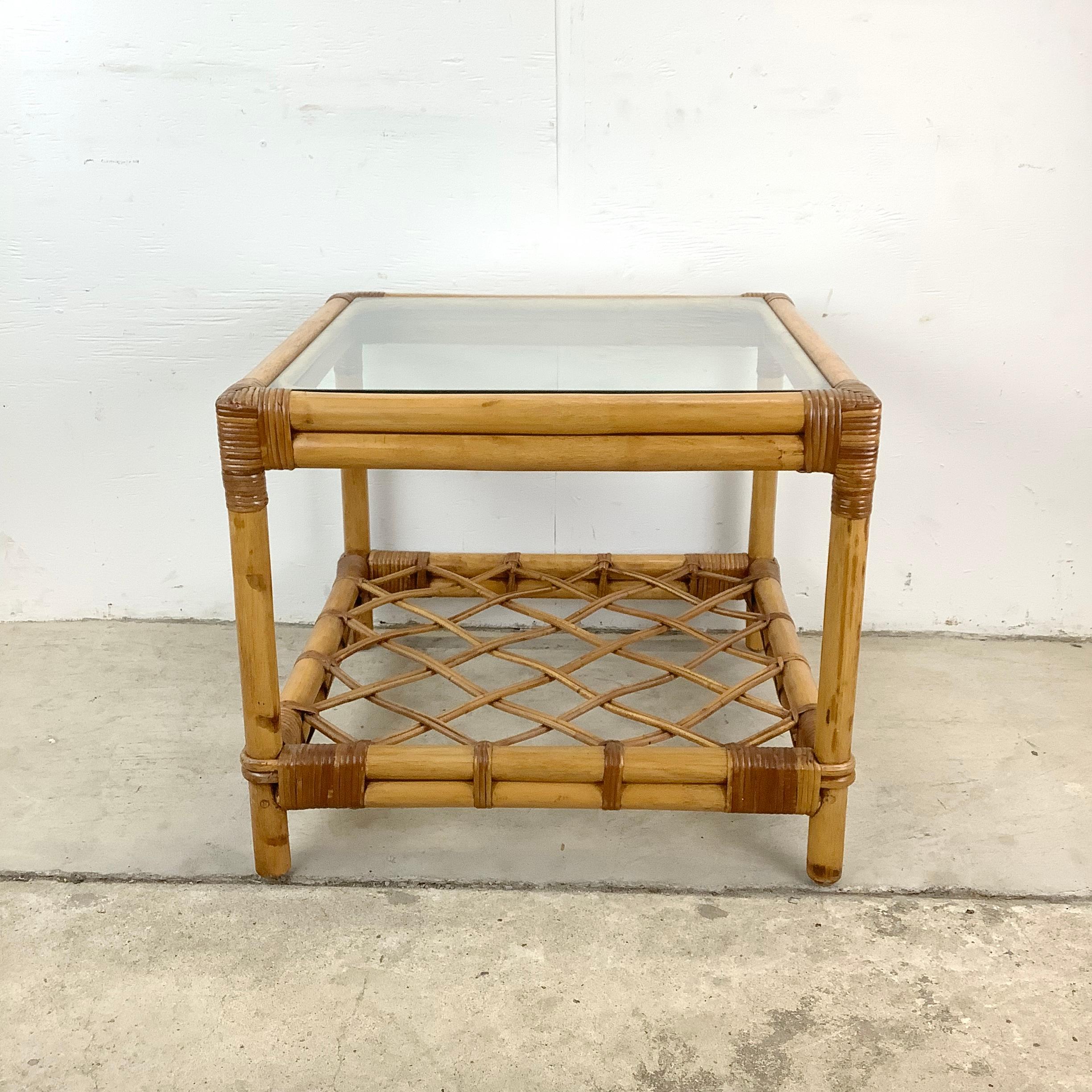 Welcome this coastal-inspired rattan side table from Ficks Reed into your home and embrace the relaxed charm it brings with its glass top and woven lower shelf. The natural rattan frame, expertly bound by intricate joints, promises durability and