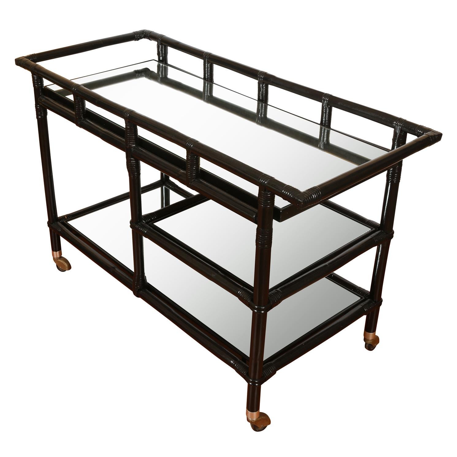Ficks Reed black lacquered rattan bar cart with mirrored shelves,. two full width and one smaller shelf.