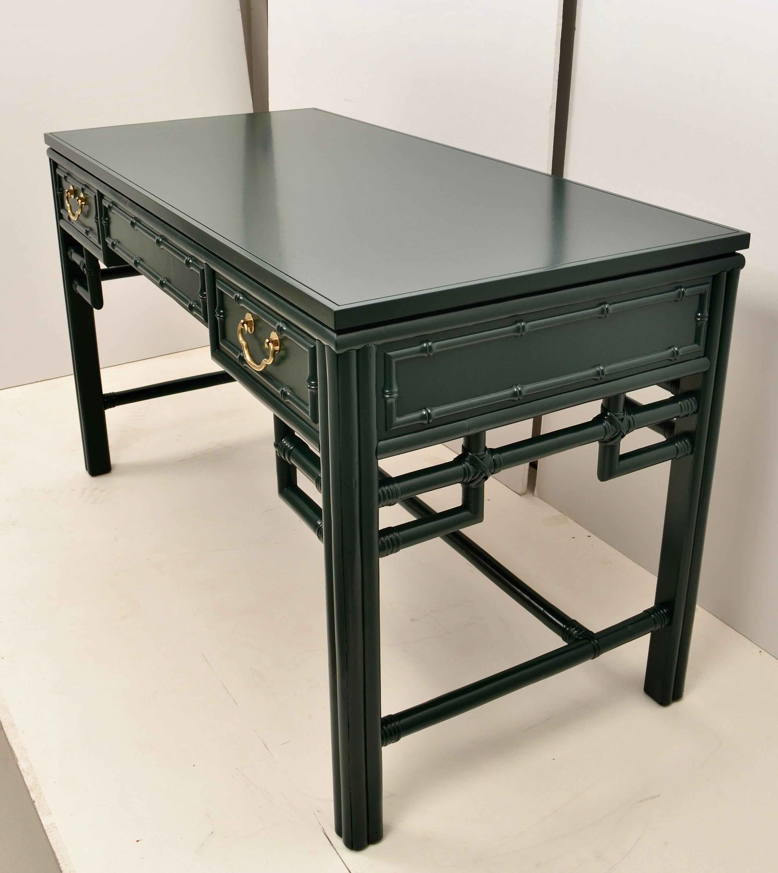 Super quality, super style. This desk by Ficks Reed with faux bamboo and chinoiserie detailing has three drawers in the front. The finished back allows the desk to be floated in the room if desired. Newly lacquered in satin BM Hunter Green. Solid