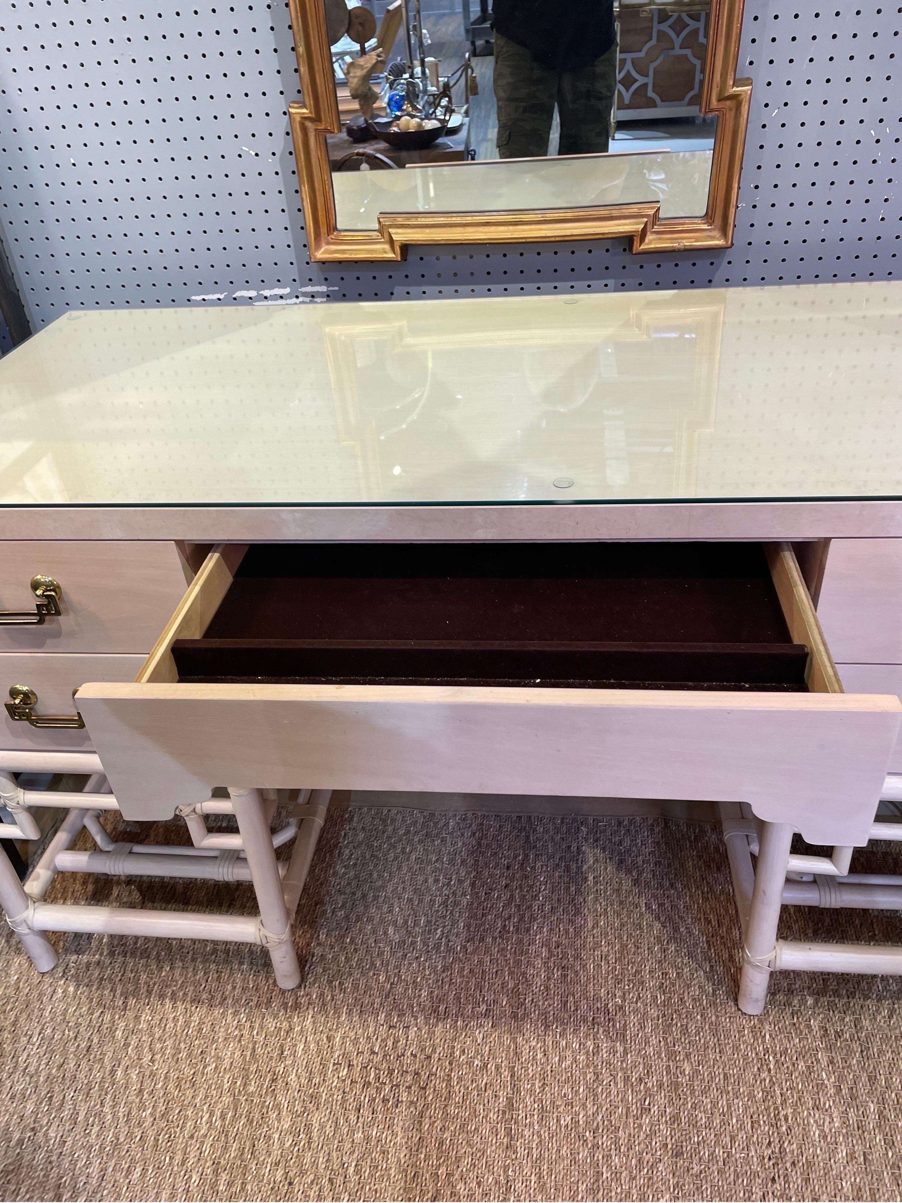 This is a vintage pickeled wood five drawer bamboo desk with brass Asian inspired handles 
This is a wonderful condition with a piece of glass on top
Made in USA 