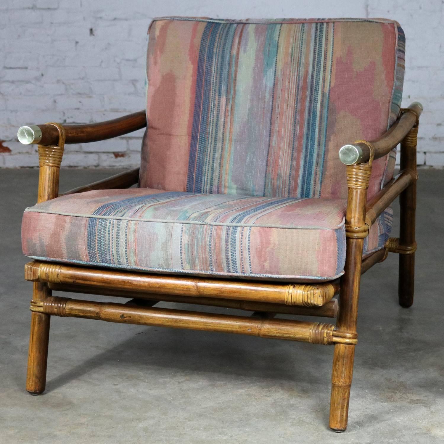 Lovely vintage Ficks Reed rattan Campaign style lounge or club chair with interesting brass cap accents by John Wisner for the Far Horizons collection. This chair is in fabulous original vintage condition. The rattan is extremely nice but, the