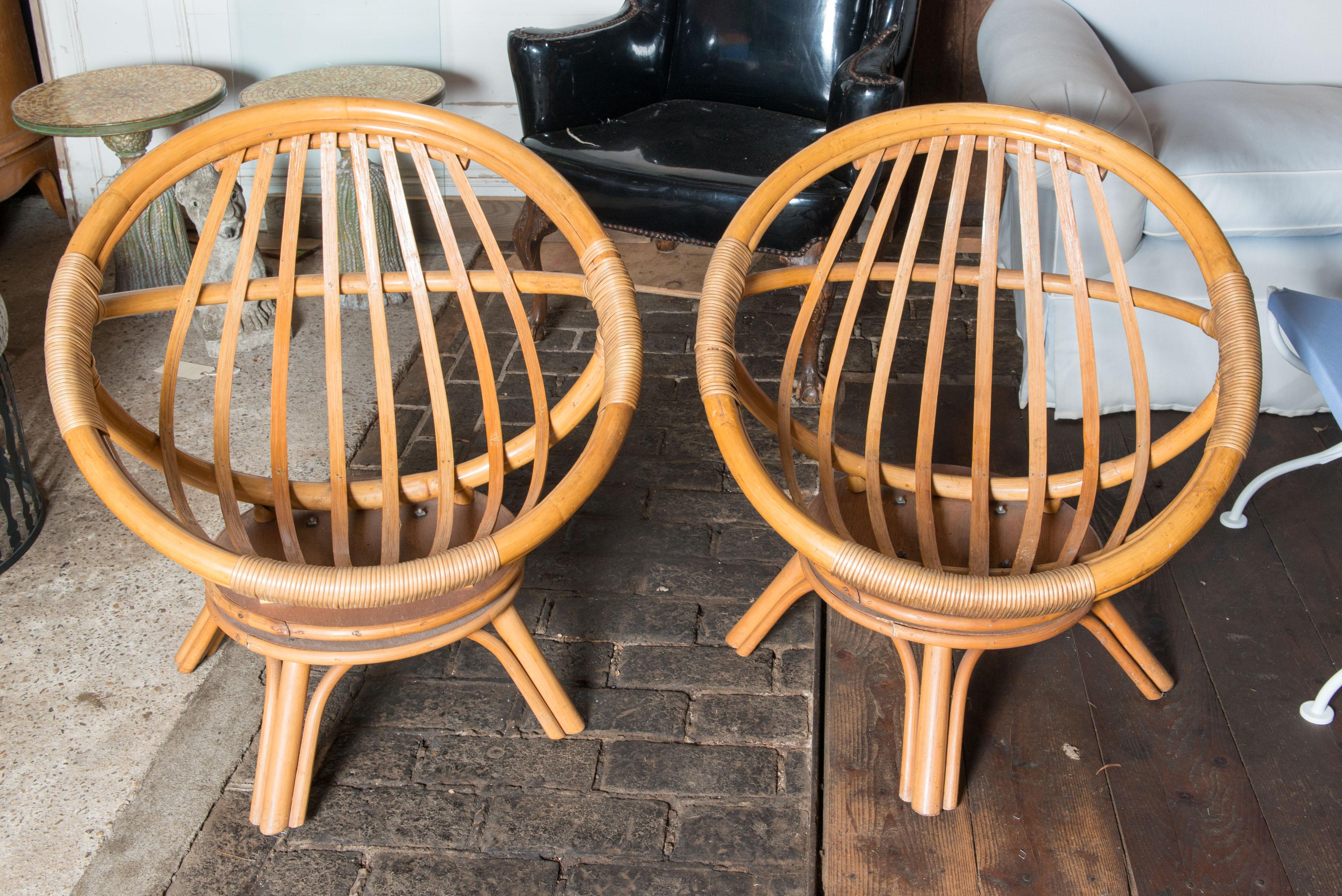 Paire de chaises longues pivotantes en forme de soucoupe circulaire Ficks Reed, conçues par John Wisner, datant du milieu du siècle dernier. En finition naturelle.
 