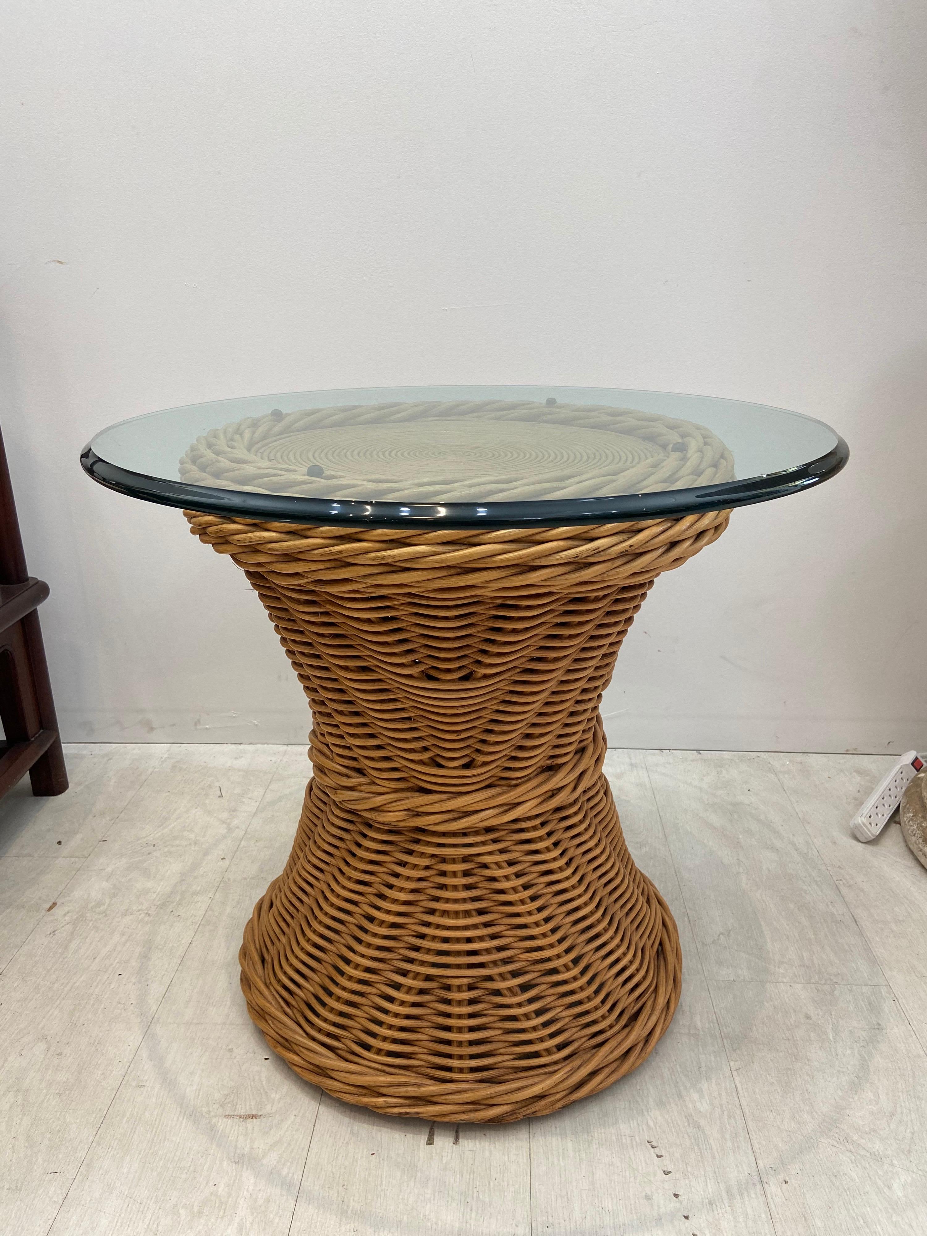 High quality rattan table with pencil reed circular pattern top. Hourglass shape with a very strong design. Three-quarter inch glass top has a few scratches. Measures: 26 inch diameter top by 23 1/2 inches tall