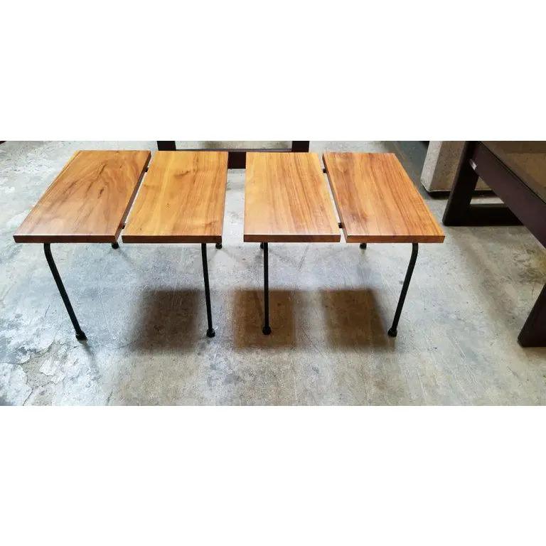 A diminutive pair of iron base end tables with solid hardwood tops and painted black iron legs. Exotic wood grain to top planks of wood. These would fit well with a low profile sofa, lounge chairs or bed.