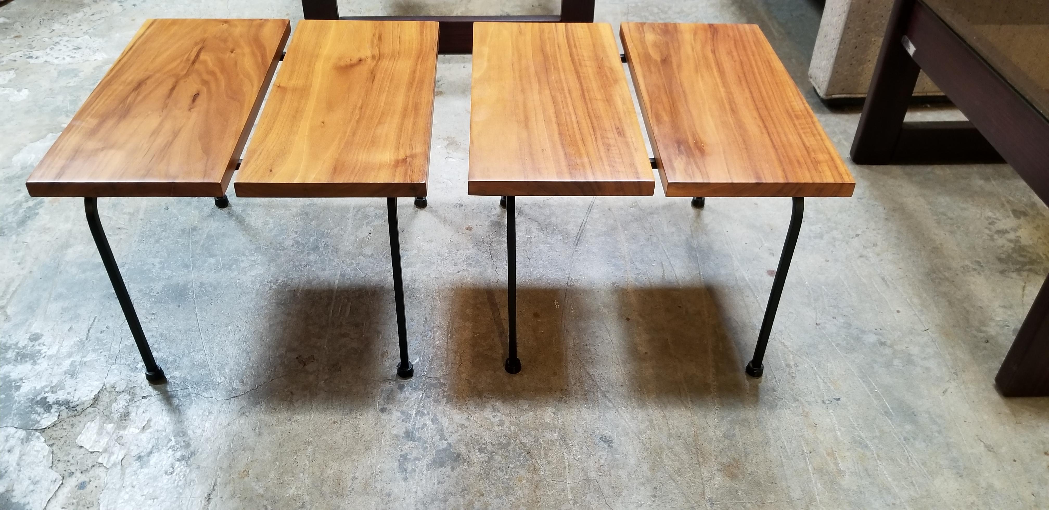 A diminutive pair of iron base end tables with solid hardwood tops and painted black iron legs. Exotic wood grain to top planks of wood. These would fit well with a low profile sofa, lounge chairs or bed.