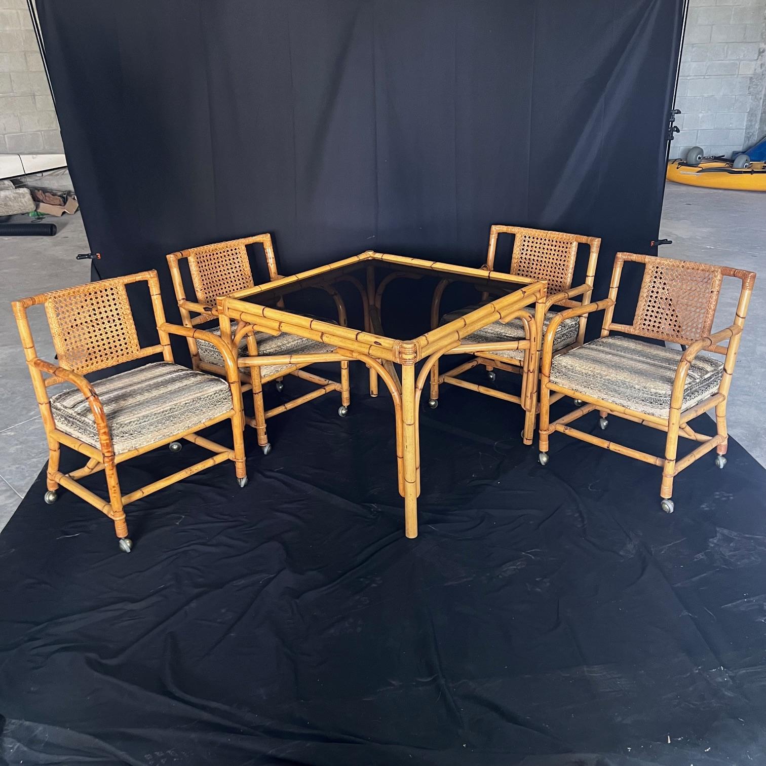  Authentic and rare mid century indoor, outdoor or patio rattan dining set consisting of  a four-strand arch legged steam bent dining table with X stretcher and four marvelous matching steam bent arm or club chairs with caning and original vintage