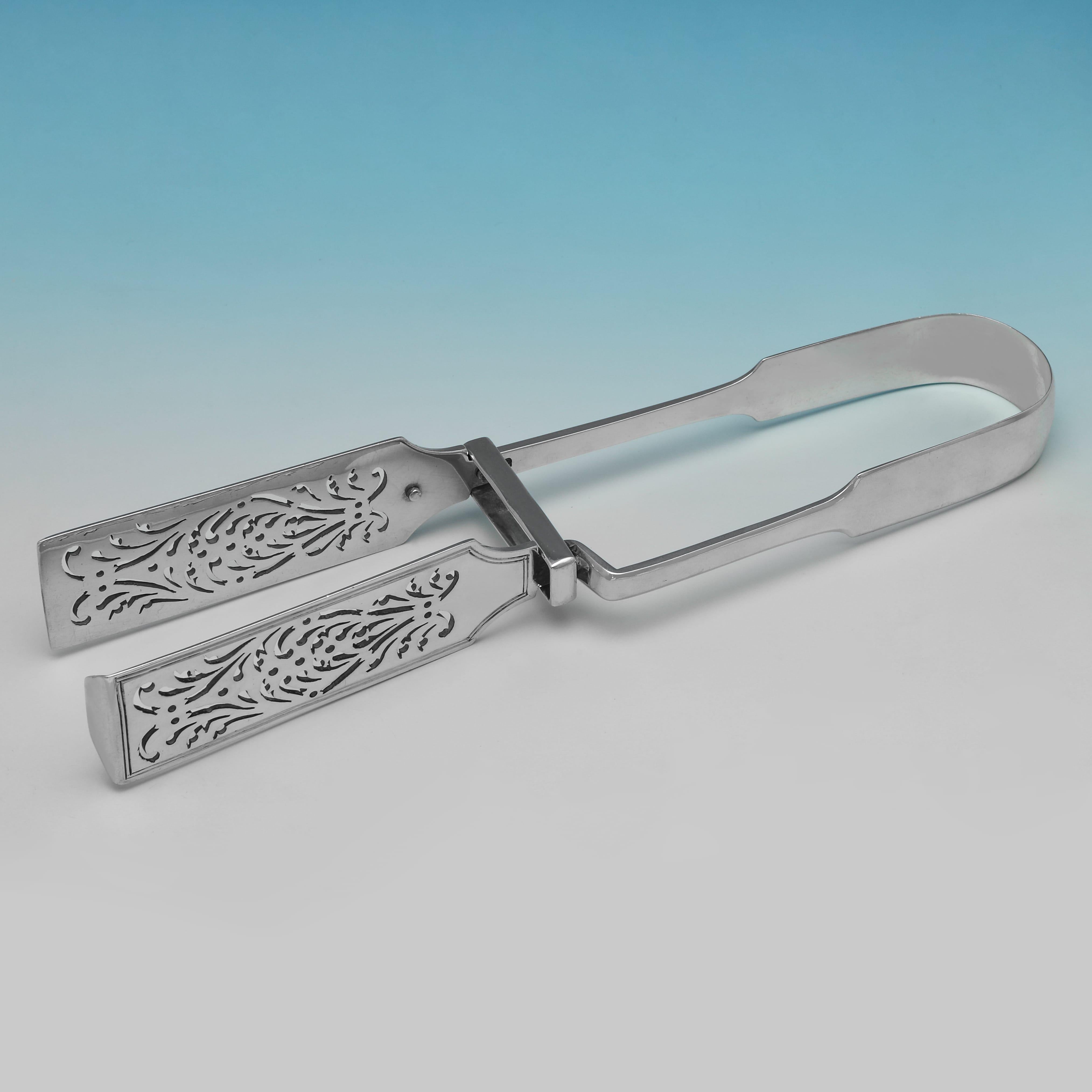 Hallmarked in London in 1838 by William Eaton, this handsome pair of Victorian, Antique Sterling Silver Asparagus Serving Tongs, are in fiddle pattern, and feature attractive pierced decoration to the tongs. The asparagus tongs measure 9.75