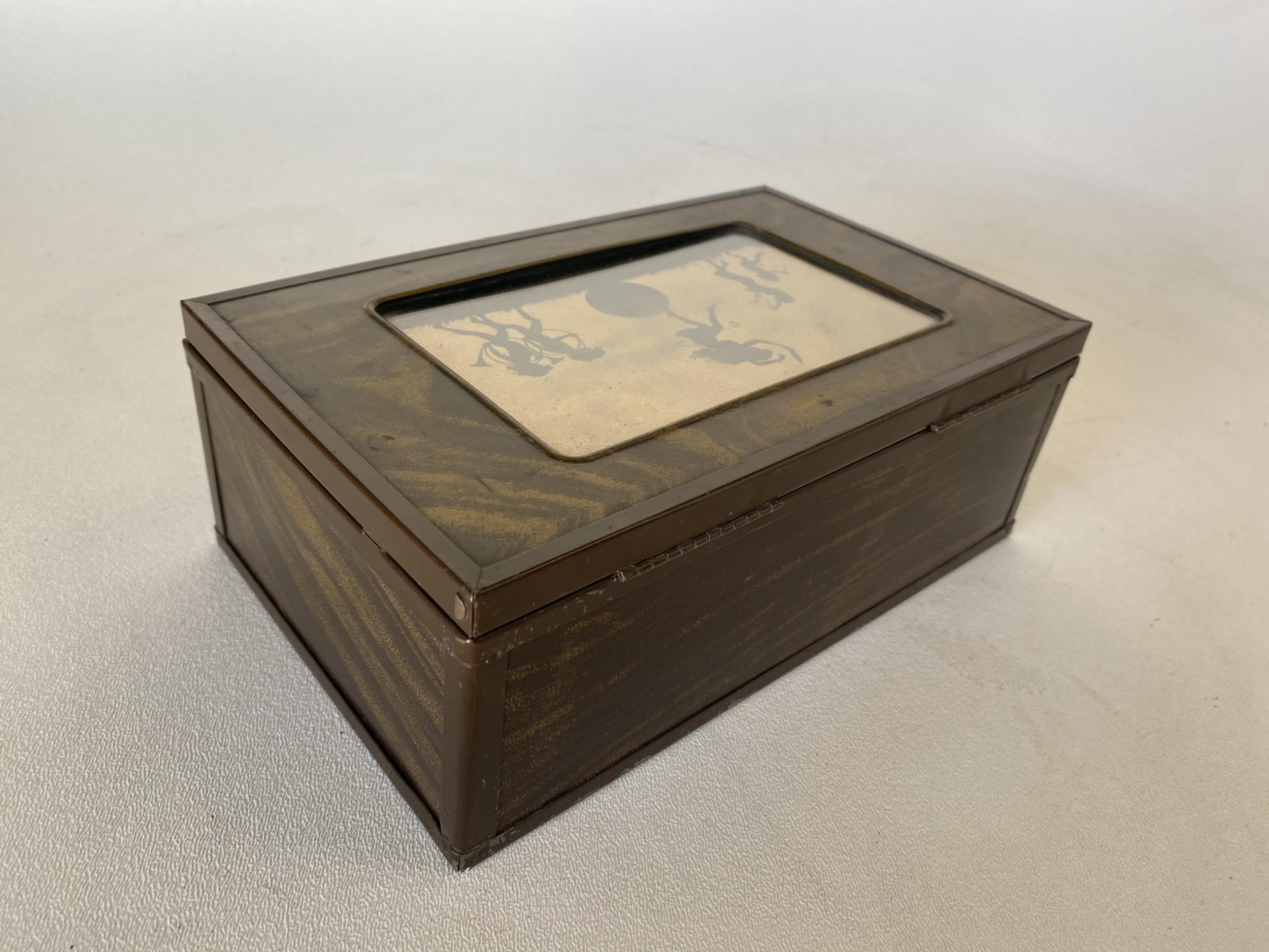 Early 20th turn of the century wood jewelry box with an enameled metal edge, red velvet interior, and small vanity mirror. The top features a small 