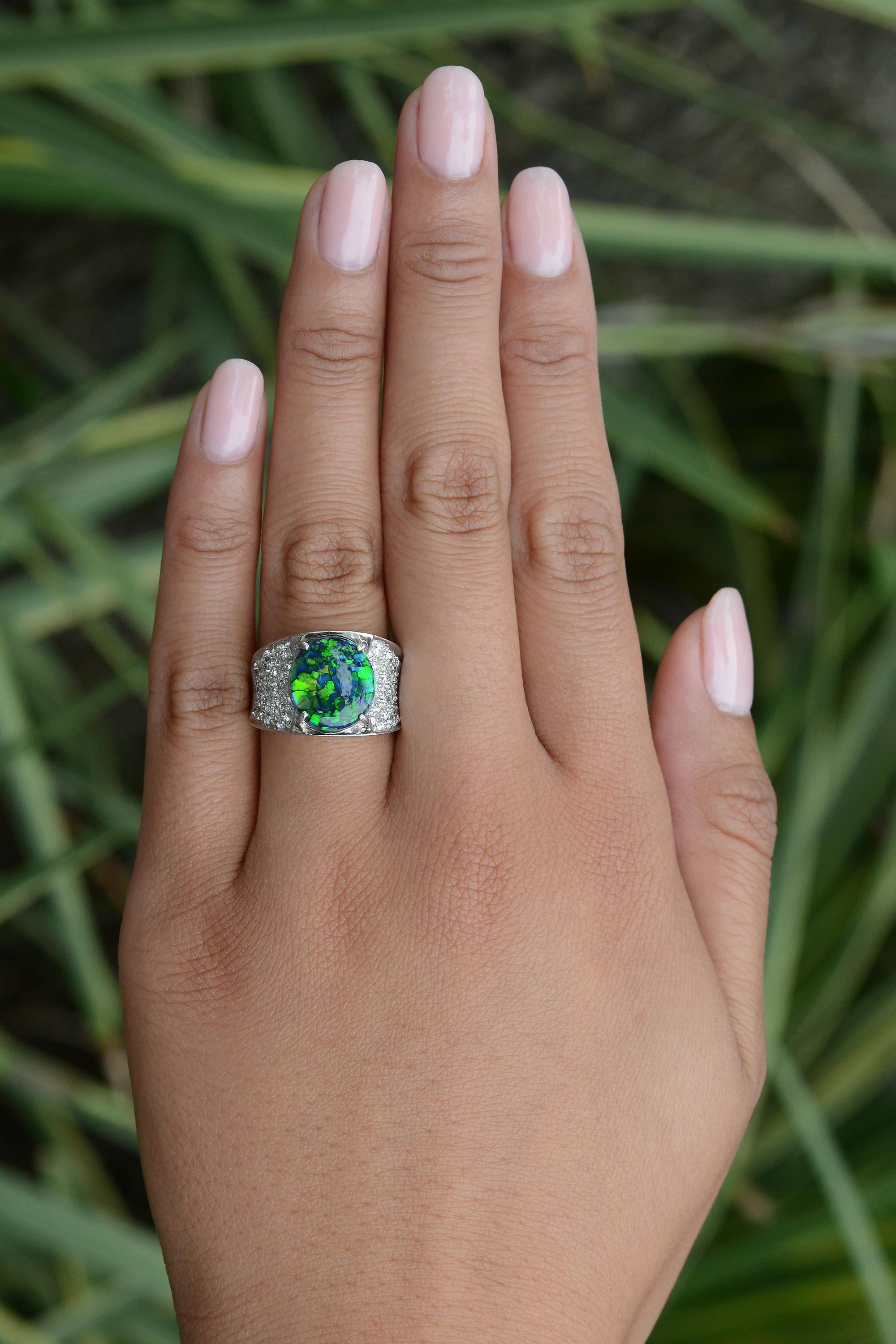This extraordinary cocktail ring features a phenomenal 3.48 carat Australian black opal with a harlequin pattern. The fantastic gemstone from the renowned Lightning Ridge mine showcases prominent bright green, blue and secondary yellow flashes. The