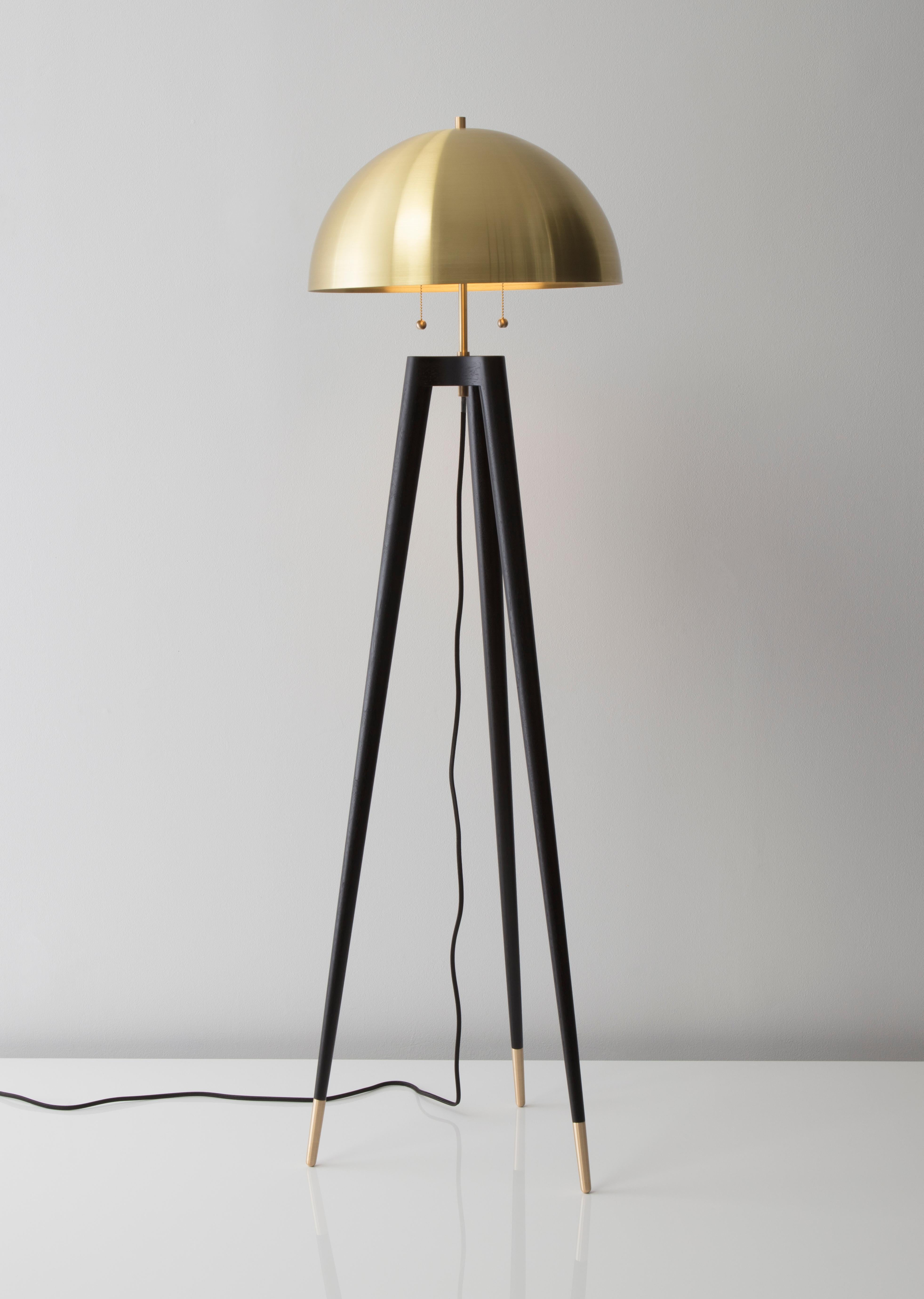 • Fife tripod lamp is lathe turned from solid walnut. The shade is spun from solid brass with a satin finish. 
• A black fabric covered cord hangs loosely from the center of the lamp's base.
• Standard cord length is 12 feet. Cord on 220V fixtures