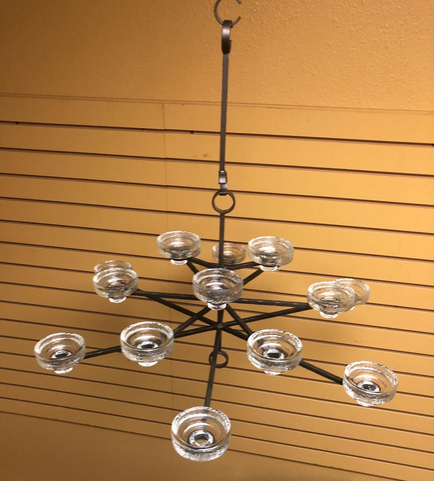 A very rare find! Gorgeous fifteen candle chandelier by Erik Hoglund for Kosta Boda, circa 1960s. The chandelier which is made of wrought iron and glass was designed and manufactured in Sweden. 

There are fifteen glass candle holders (that