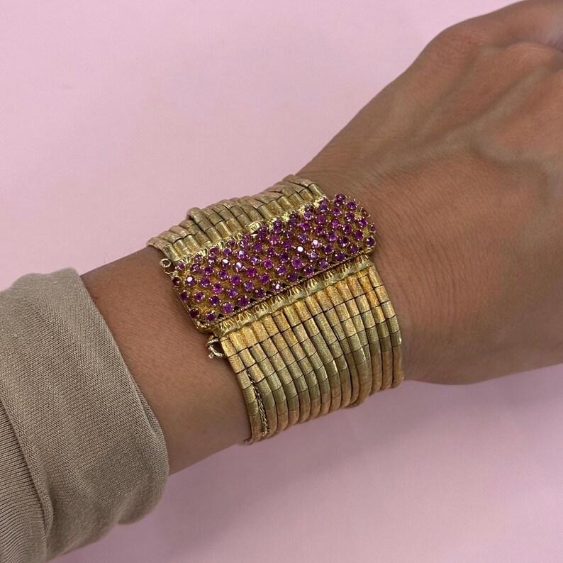 18 Karat Yellow gold bracelet featuring 15 rows of multi strands in a brushed finish and a Pink Sapphire clasp weighing 119.2 grams.
So comfortable and feels like silk.

More Multi Strand Bracelets & Necklaces in Stock.
Message for Pictures &