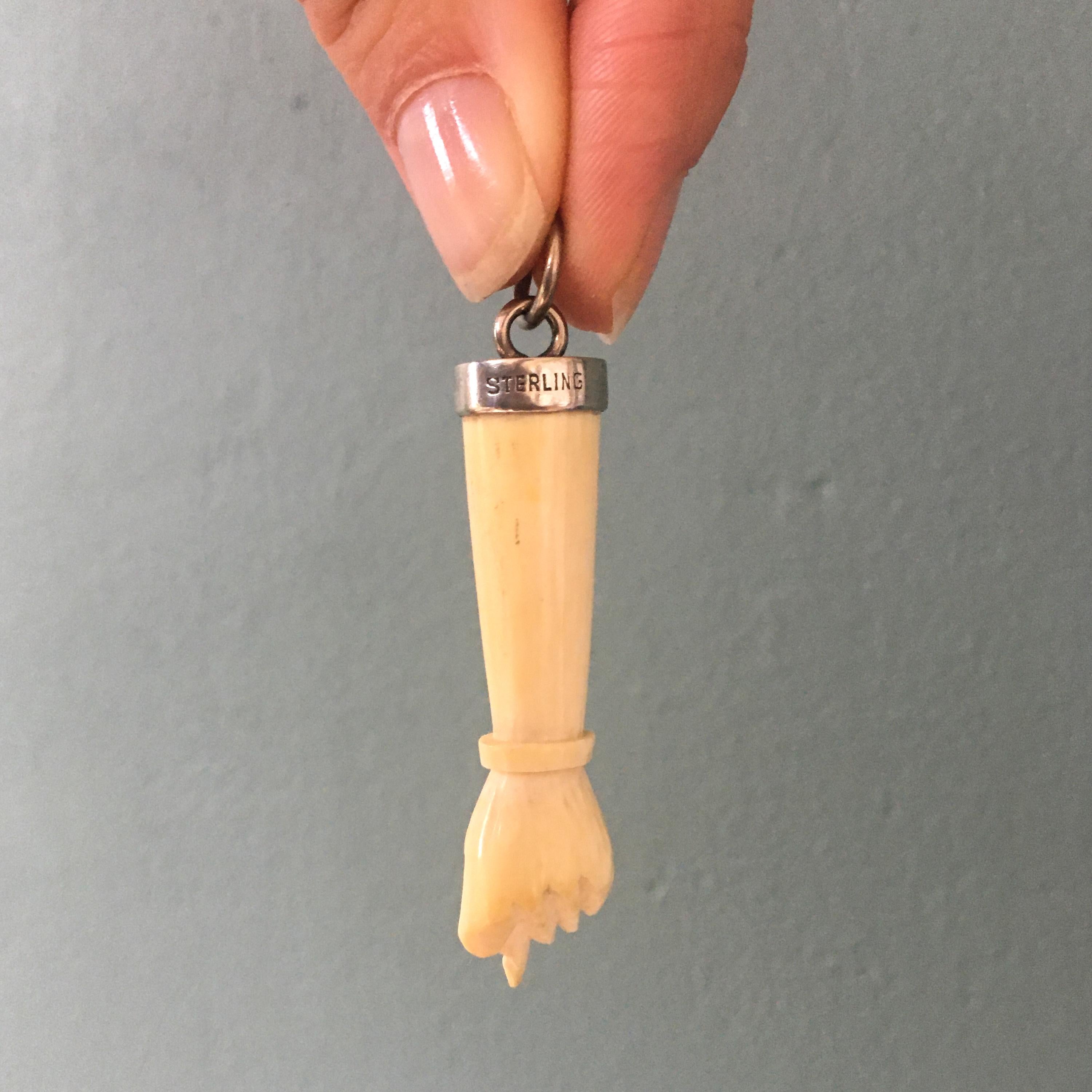 Un ciondolo amuleto in osso di mucca (toro) d'epoca montato in argento, con l'iconico simbolo della figa o della mano fico - proprio il tipo di gioielli che i visitatori del Grand Tour in Italia preferivano in passato. Questi amuleti venivano