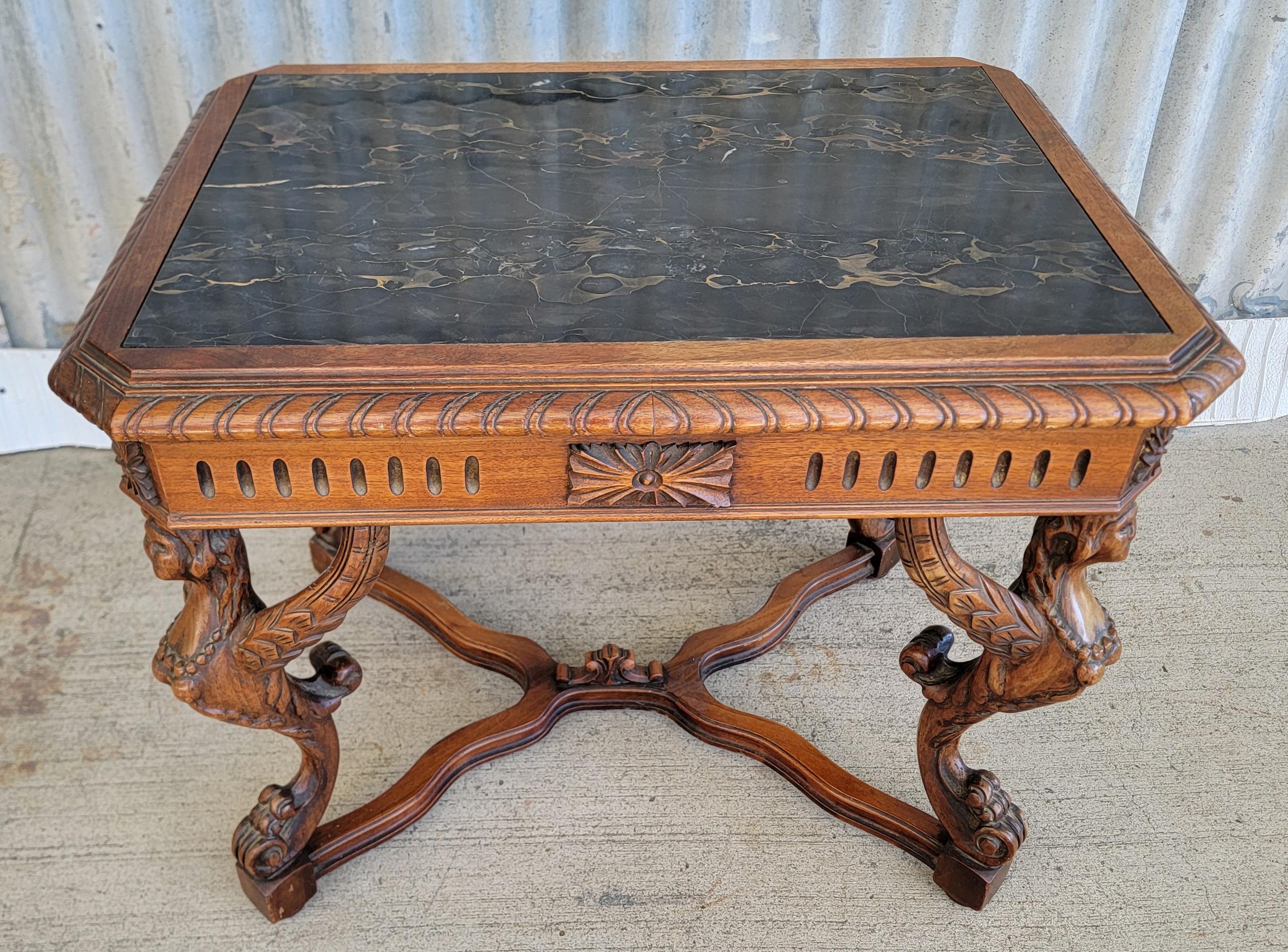Figural carved Italian Renaissance Revival end table with four winged female griffins and black marble top. Circa. 1930's. Excellent original vintage condition and original finish.

19.25 inches Deep.
25.5 inches Wide.
20.75 inches High.