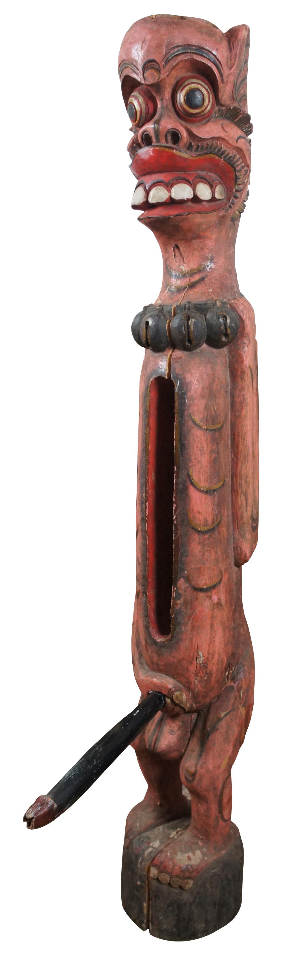 Vintage Indonesian hand carved wooden slit drum / tribal fertility figure painted in red and black with bells around it's neck and open space in the torso to store the detachable phallus / penis.

Mesures : 8