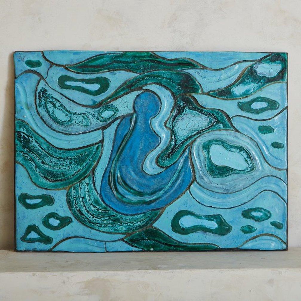 A 1970s glazed ceramic wall artwork sourced in France featuring a range of blue and turquoise hues in an abstract design. This piece has complex textural details and reminds us of the ocean. Artist initials in the upper left corner.

 