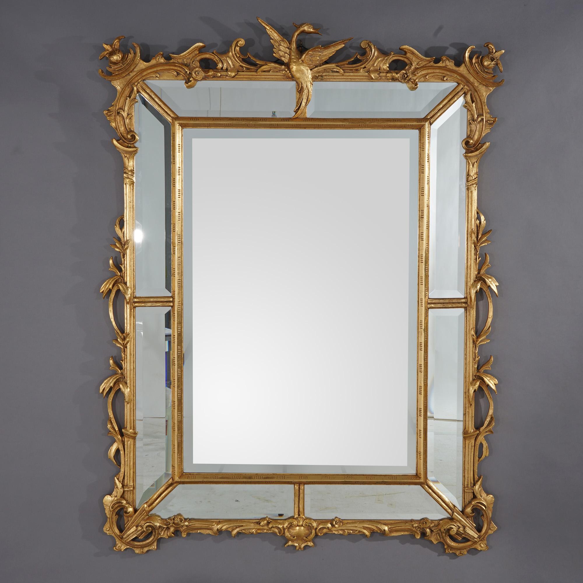 A figural parclose Chinese Chippendale wall mirror offers giltwood construction with phoenix finial over stylized scroll and foliate frame housing beveled mirror plates, 20th century

Measures - 58.5