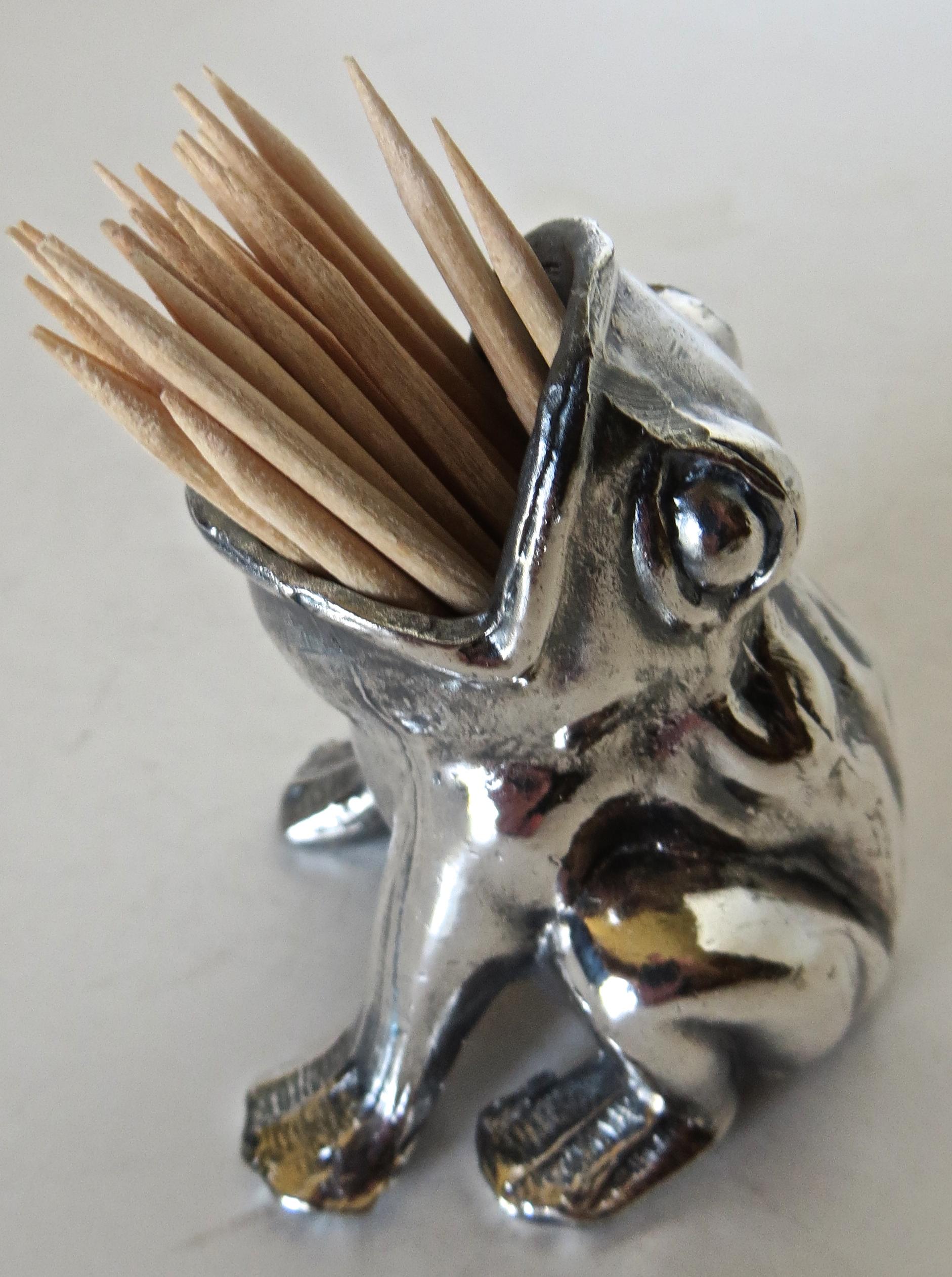 Although unmarked, this item is probably of American manufacture, as were most silver plated figural items during this era. Whimsical subject matter of a frog on all fours with mouth wide open provides a nice cavity for holding toothpicks. The frog